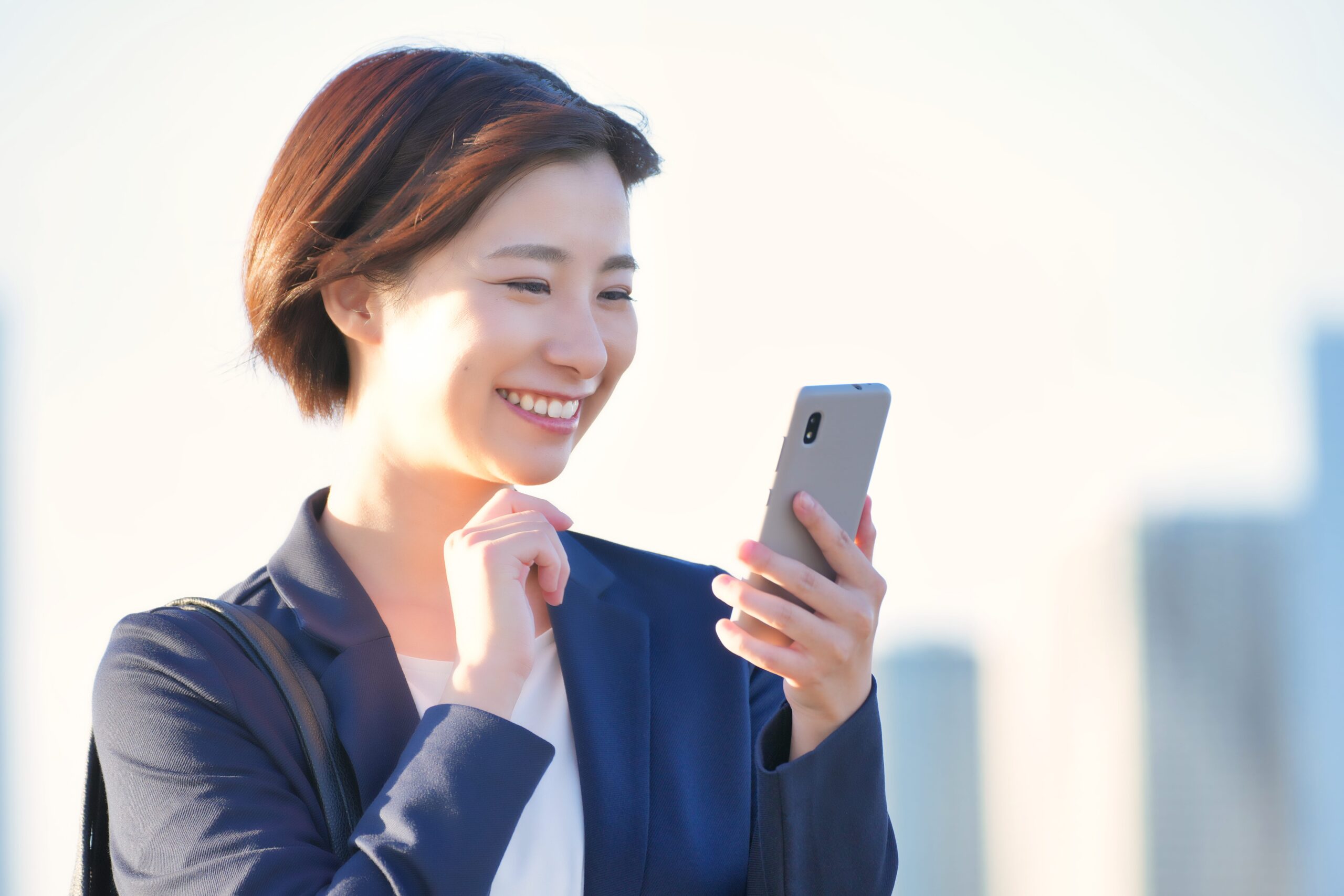 顎に手をあててスマホを見る女性