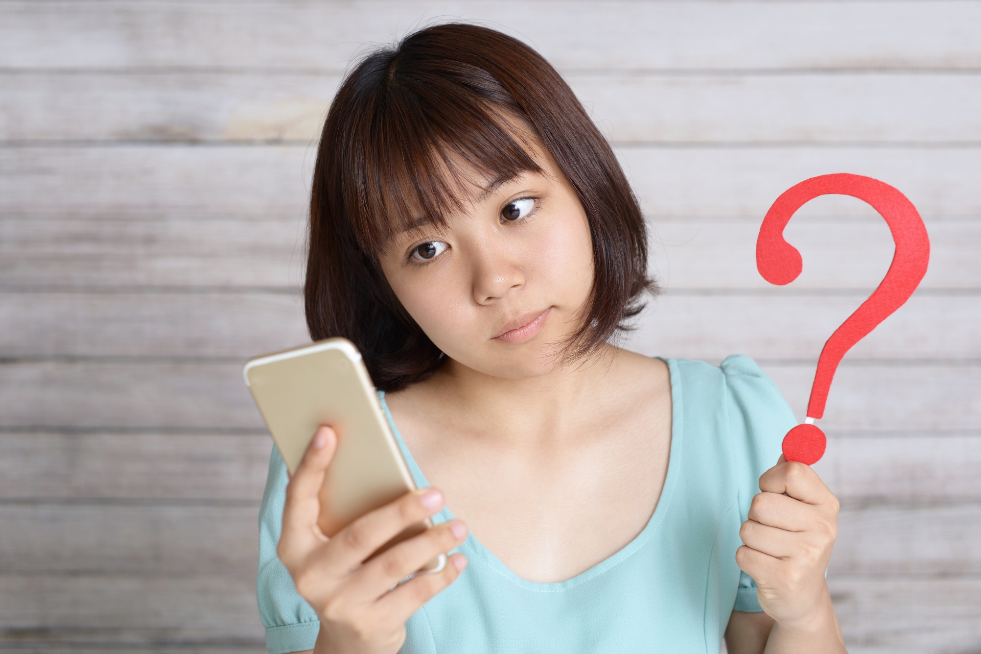 スマホを見て考える女性