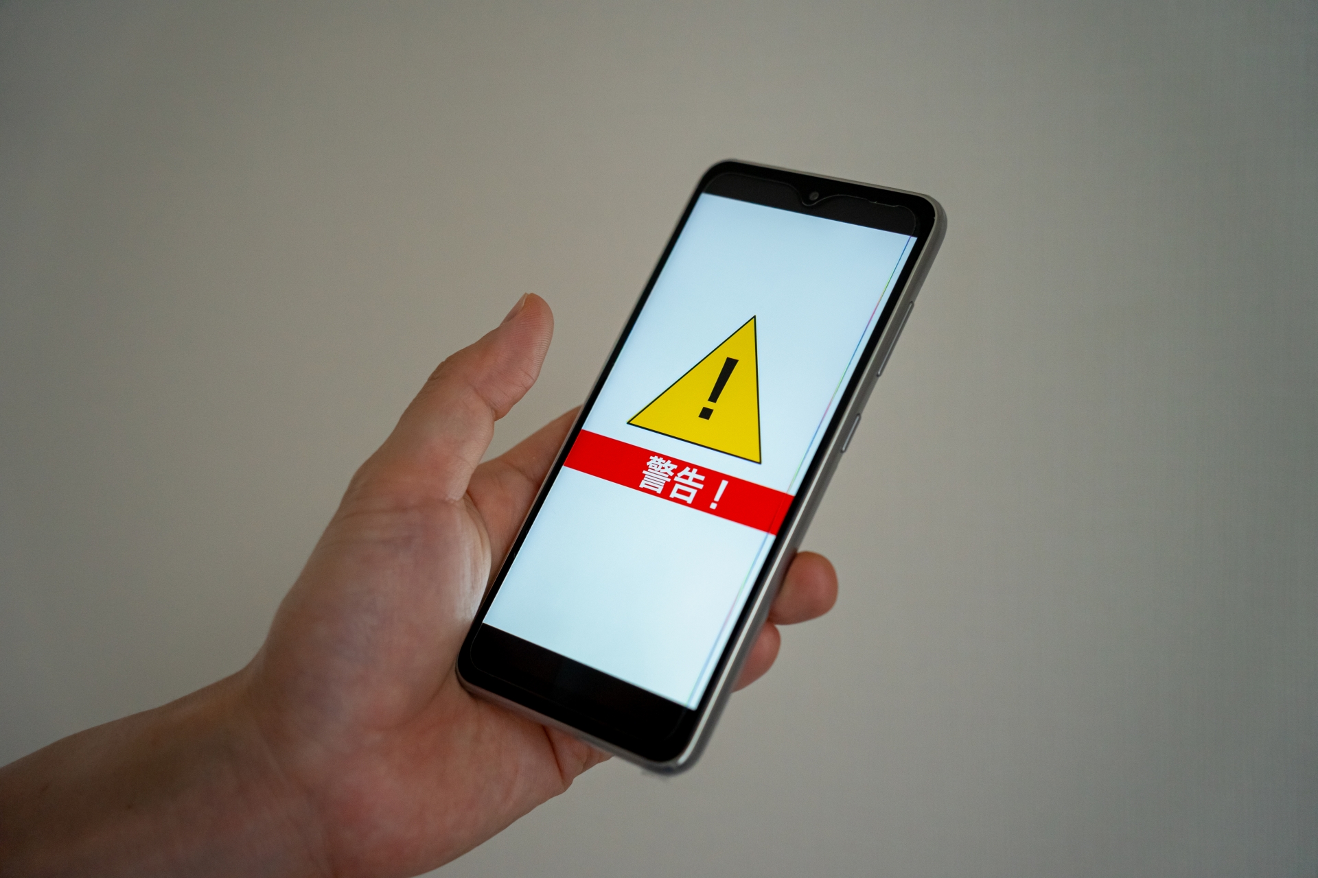 スマホ画面と警告マーク