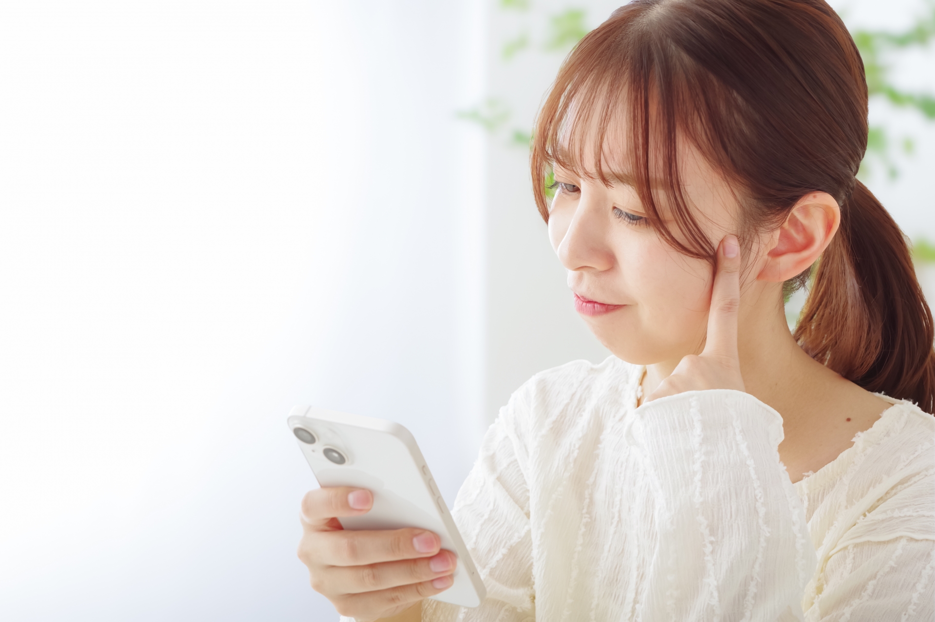 スマホを見て冴えない表情をする女性