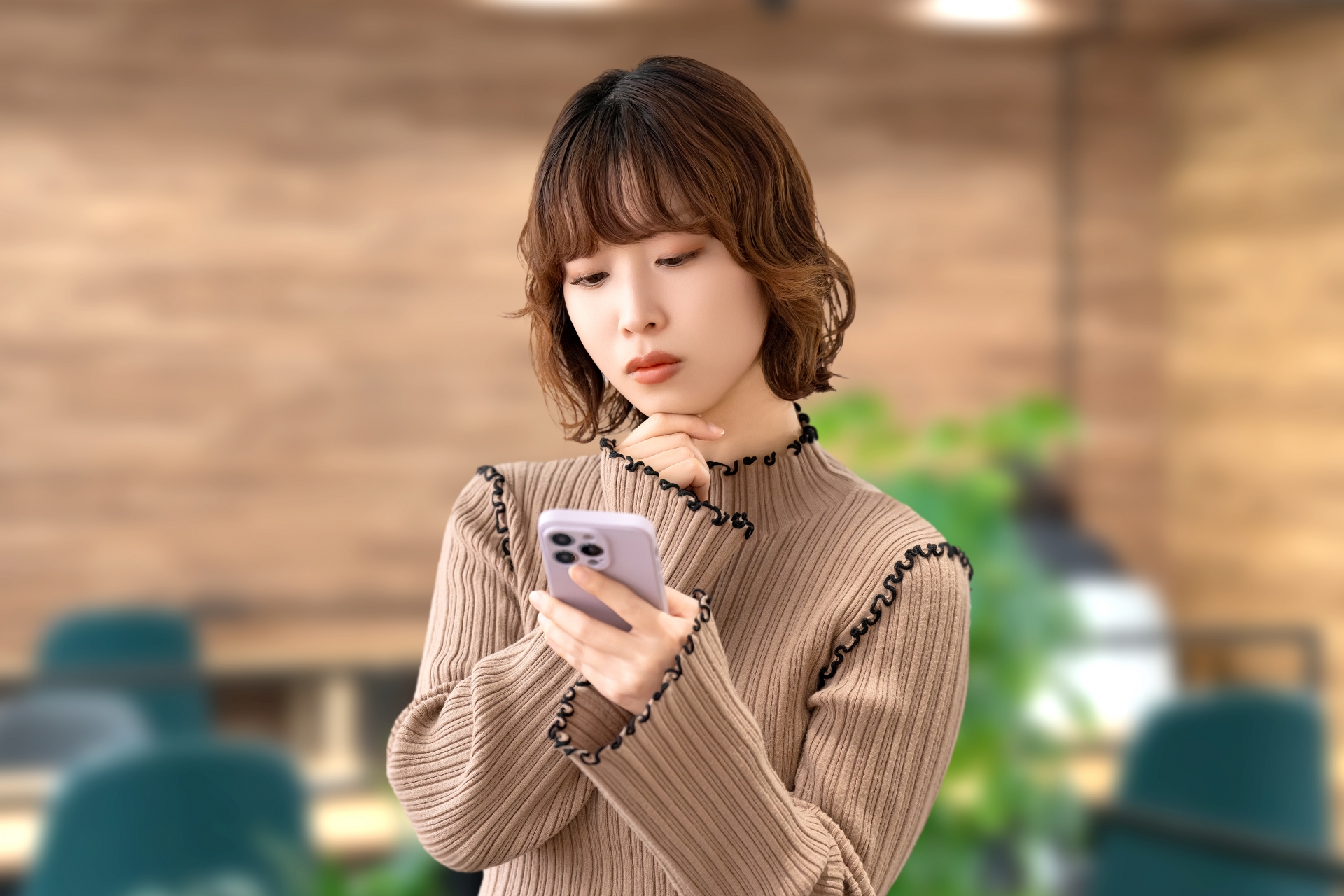 スマホを見て考える女性