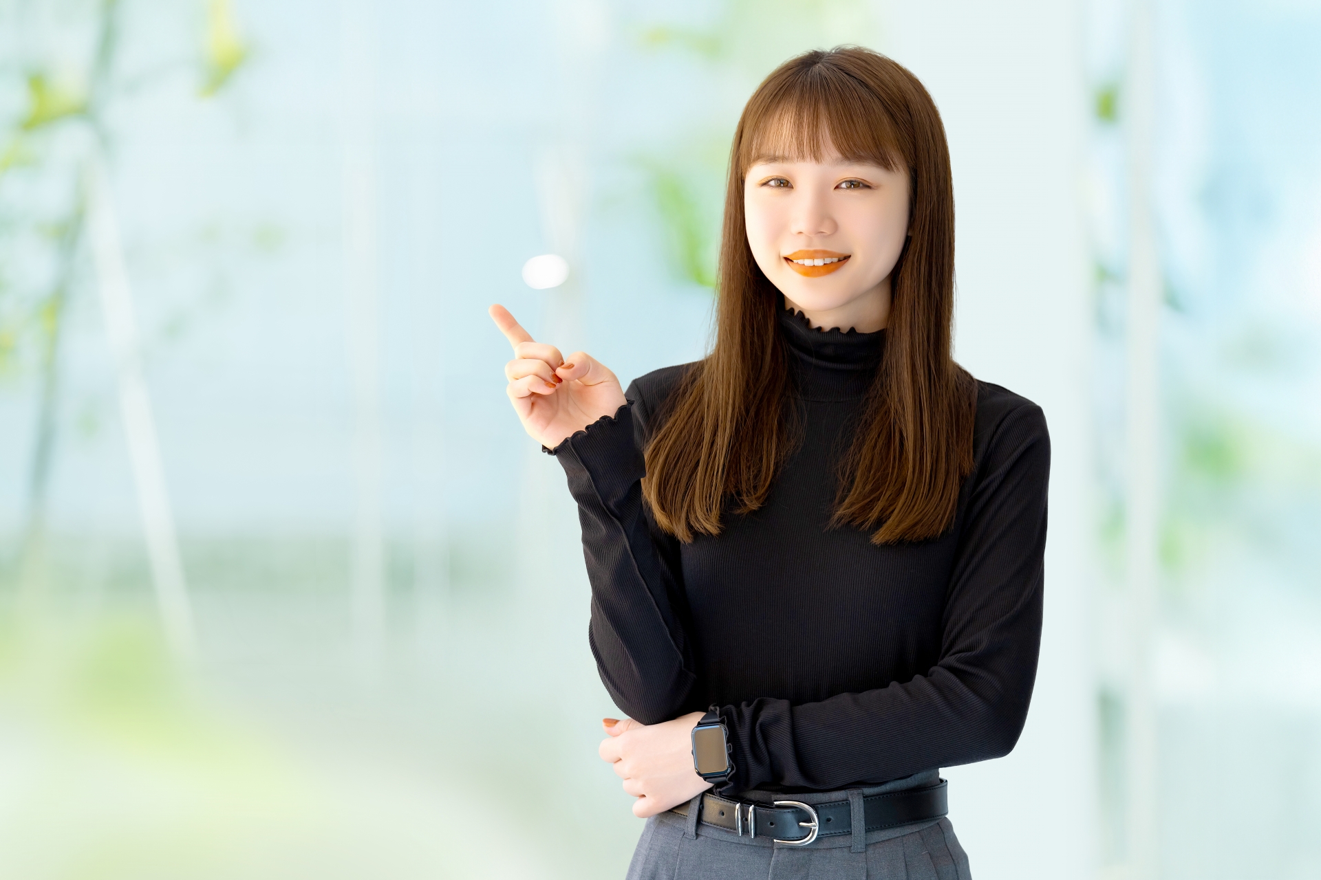 人差し指を立てて案内するビジネスウーマン