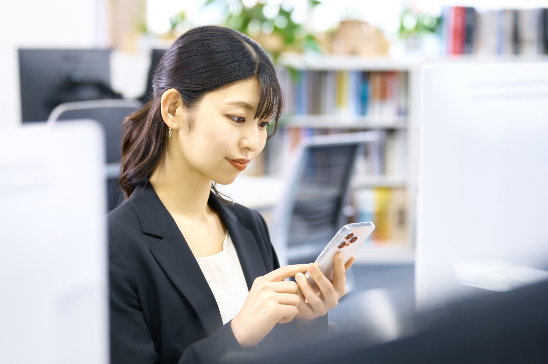 仕事中にスマホをチェックする女性