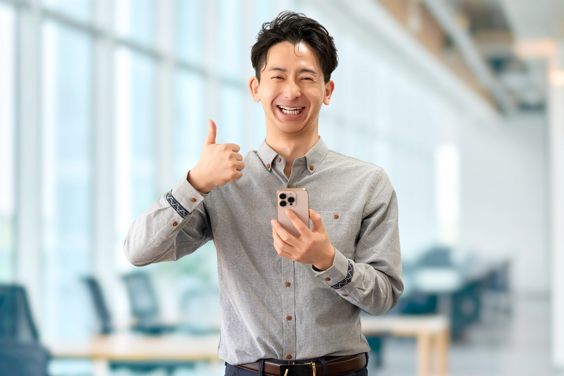 スマホを持っていいね！のポーズをする男性