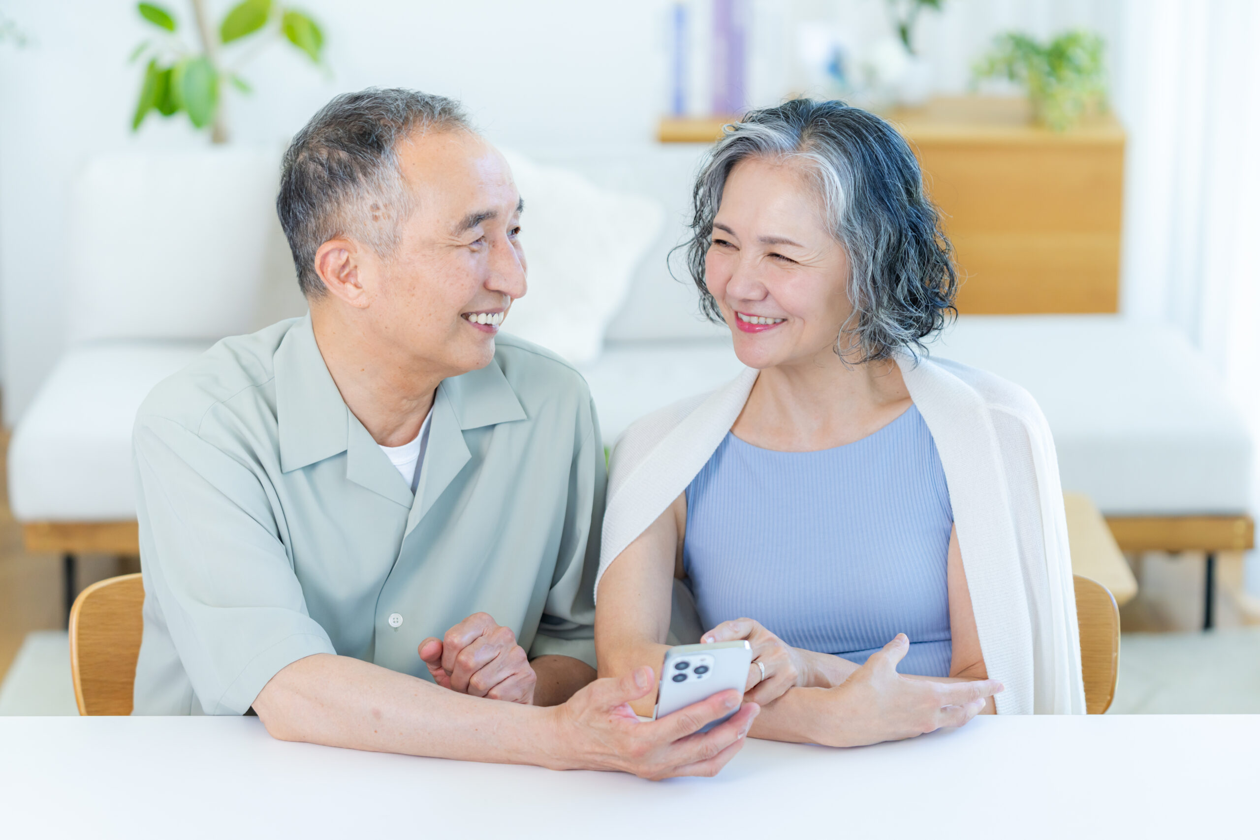 リビングでスマホを見るシニア夫婦