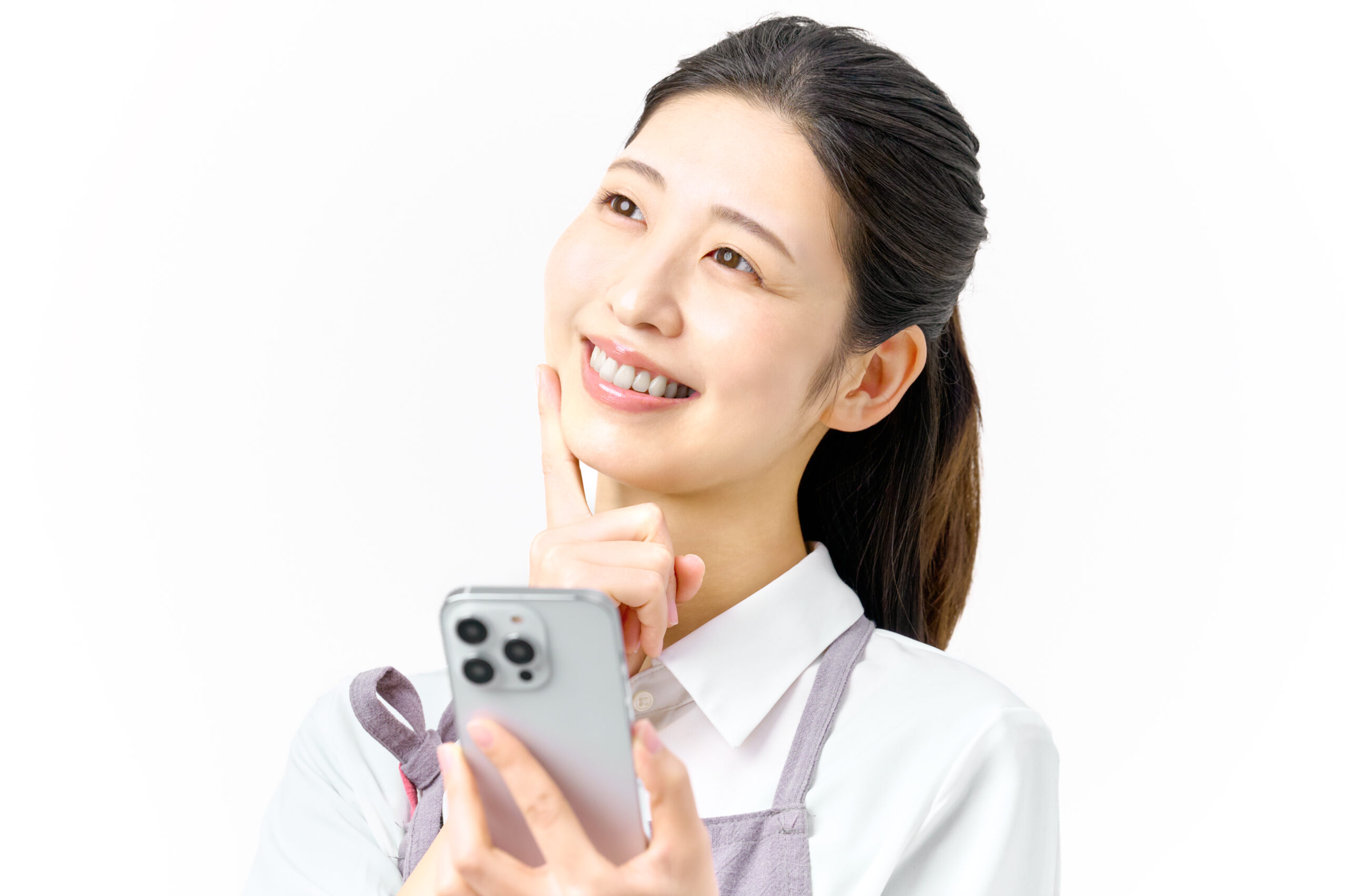 スマホを持ち考える笑顔の主婦　