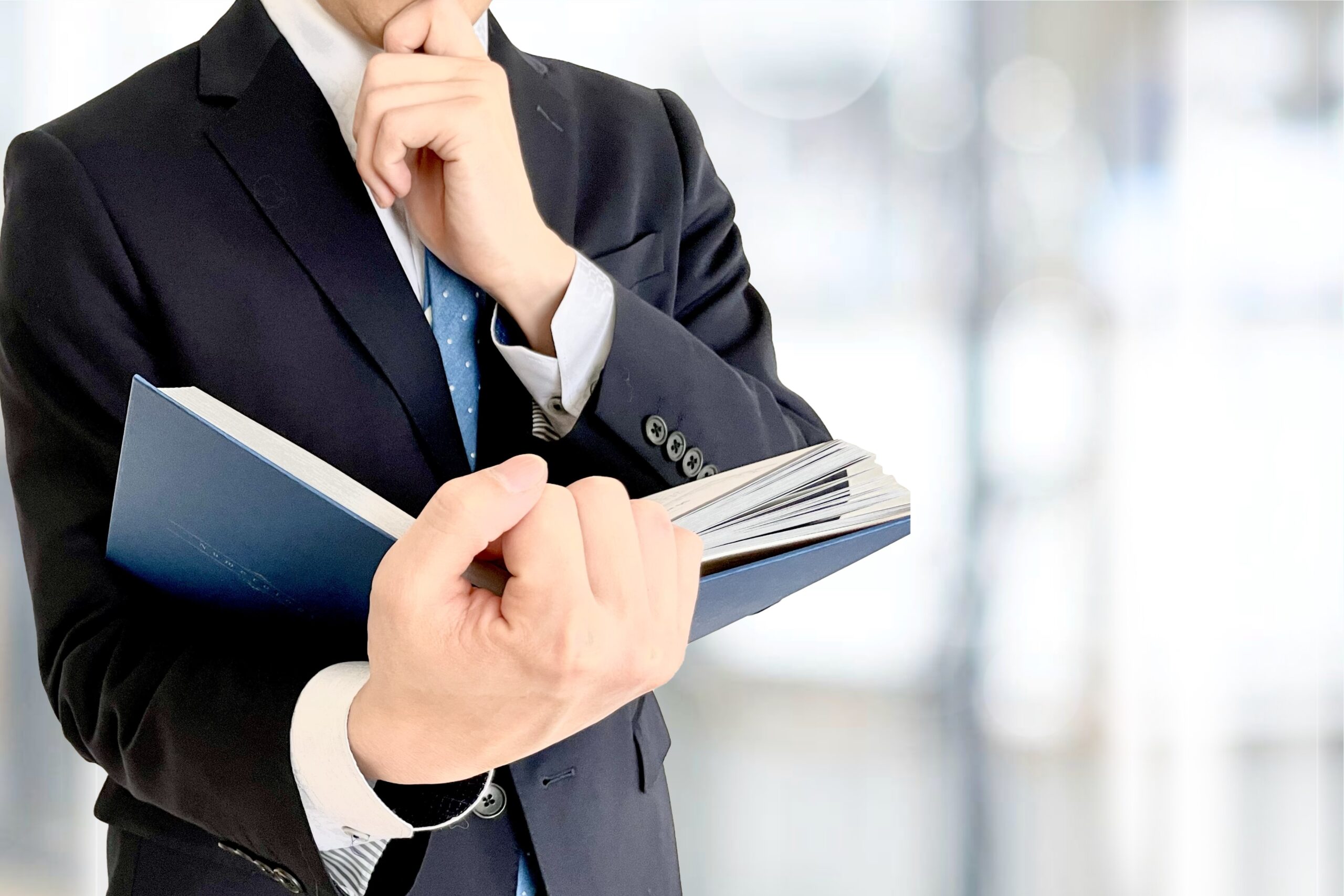 本を読むビジネスマンと社内背景