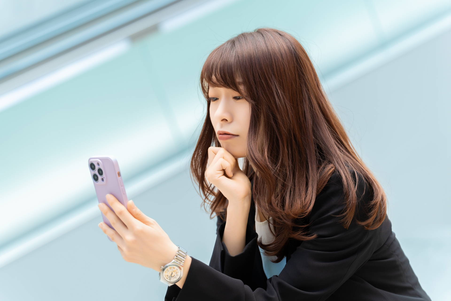 スマホを見て考える女性