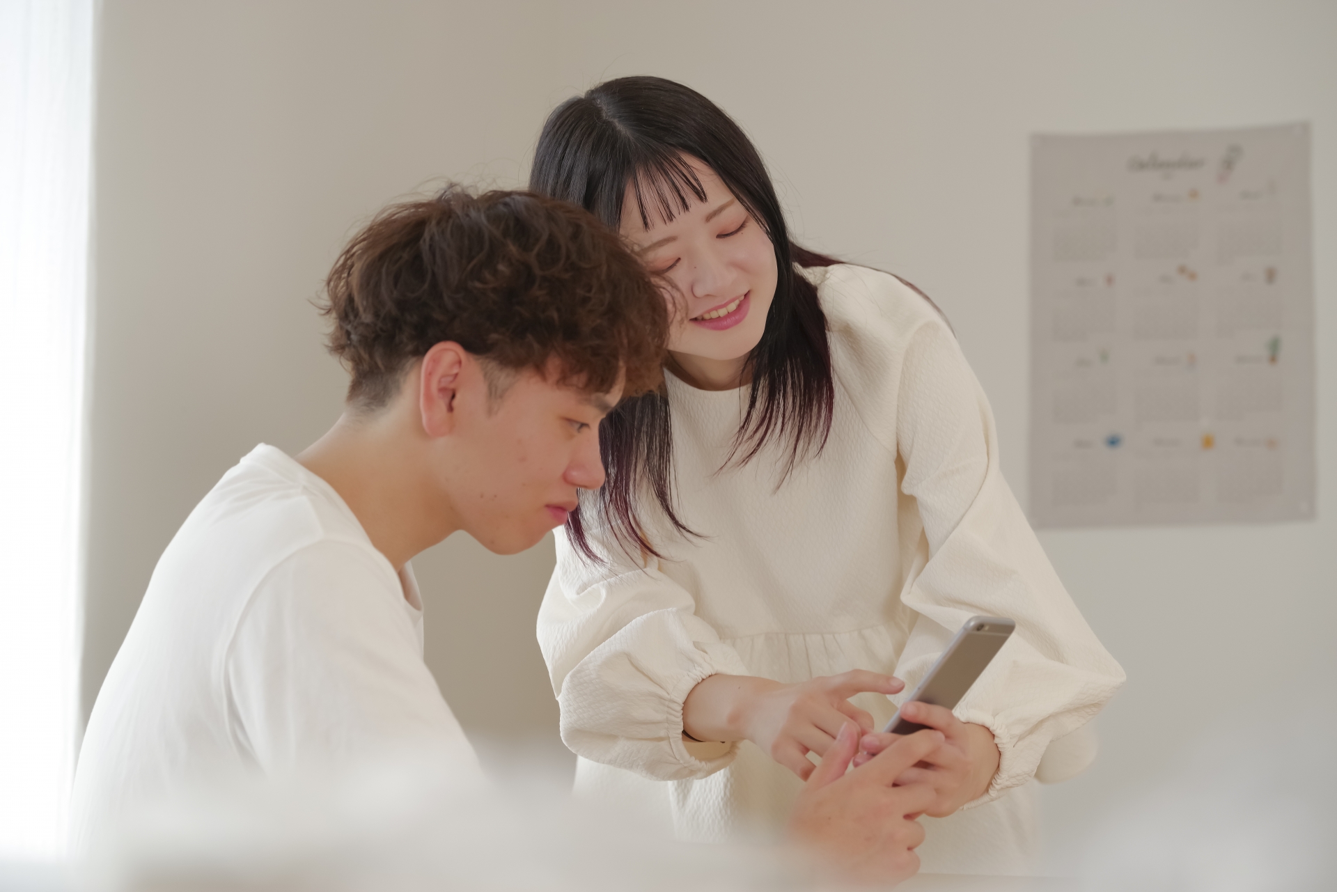 スマホで積立や貯蓄の計画を立てるカップル