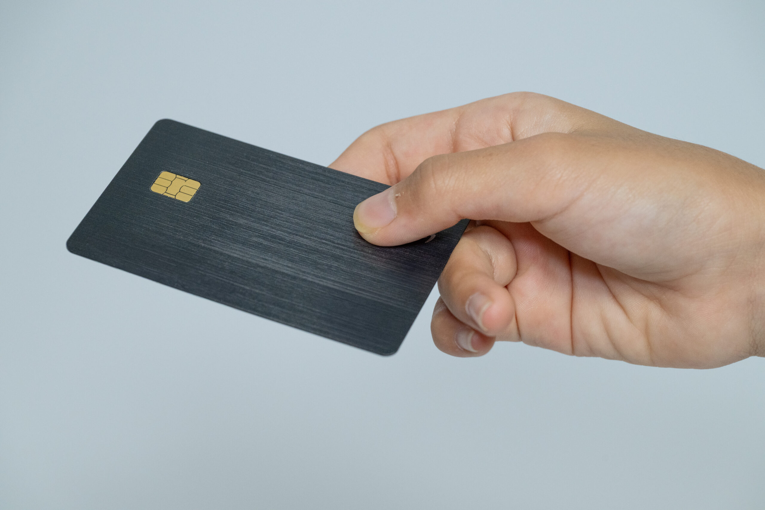 ブラックのICチップ付きカードを渡す手