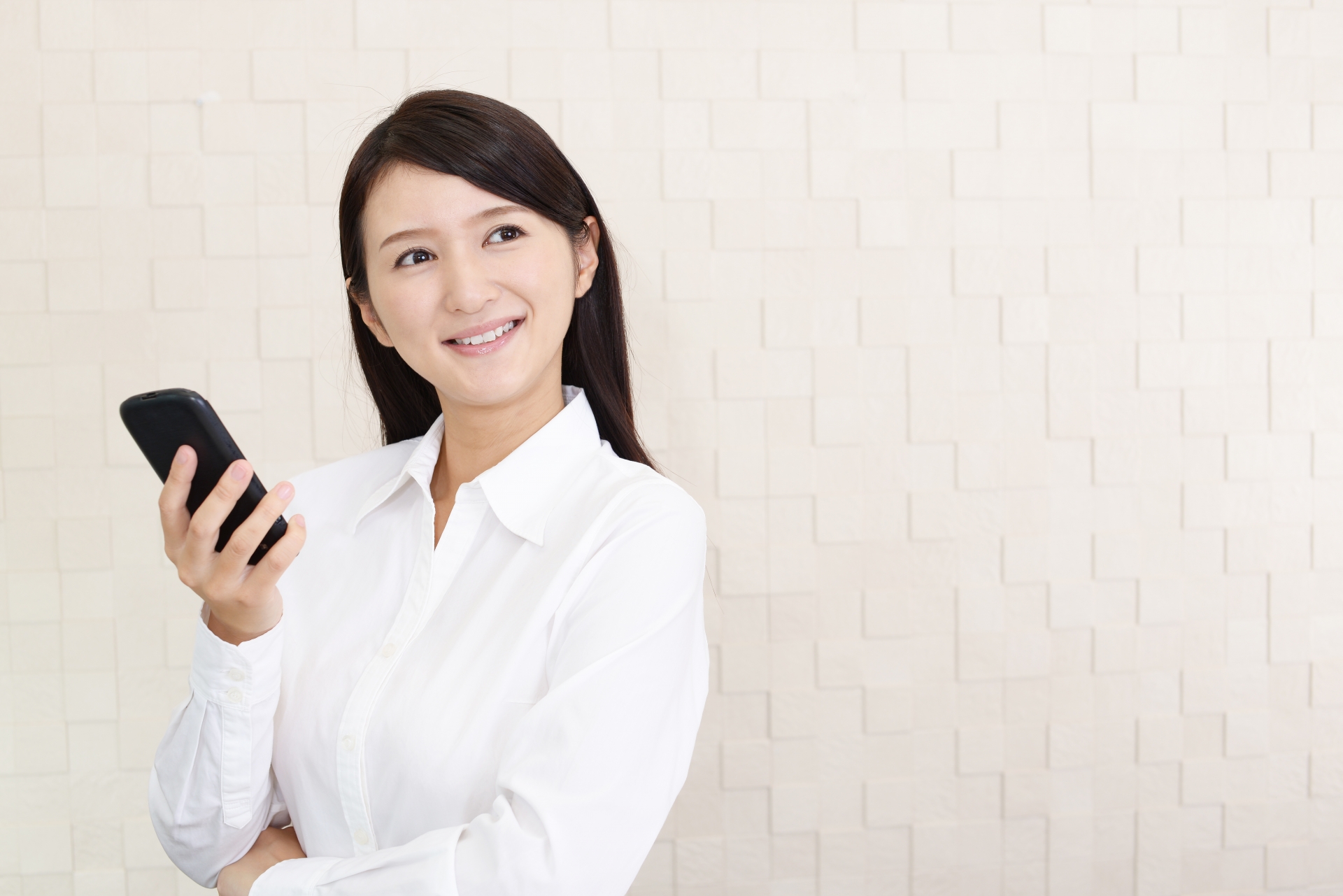 スマートフォンを持ち微笑む女性