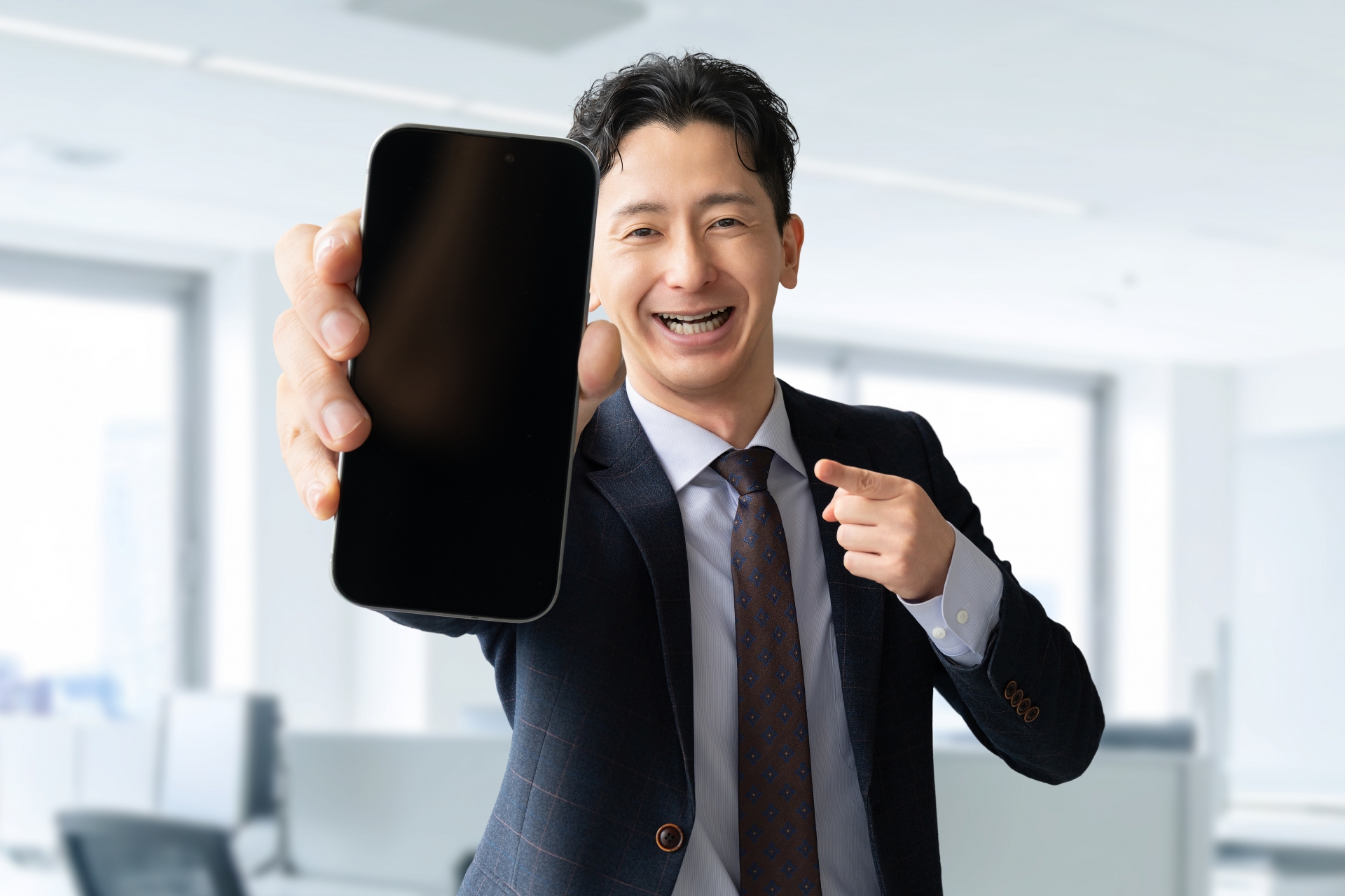 スマホの画面を見せる男性ビジネスマン