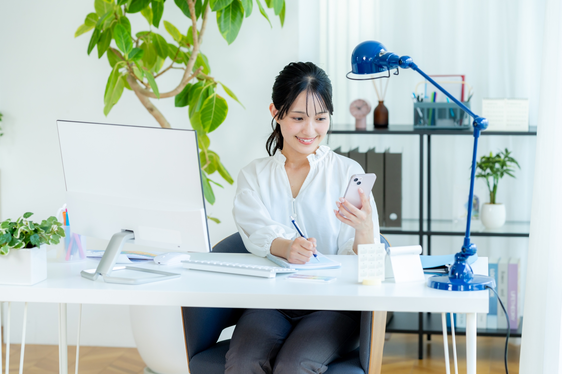 オフィスでスマホを持つビジネスウーマン