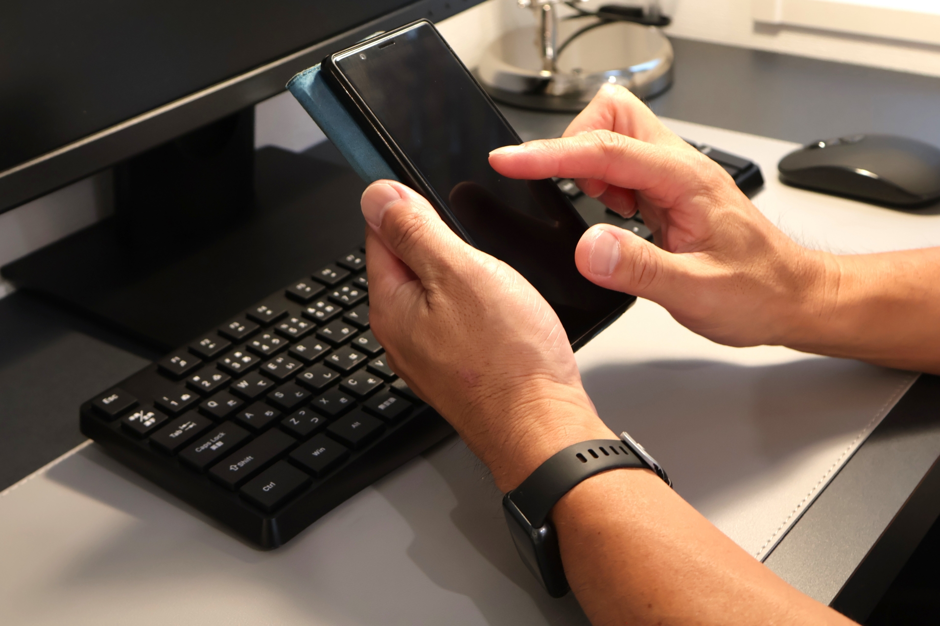 パソコンの前のスマホを操作する