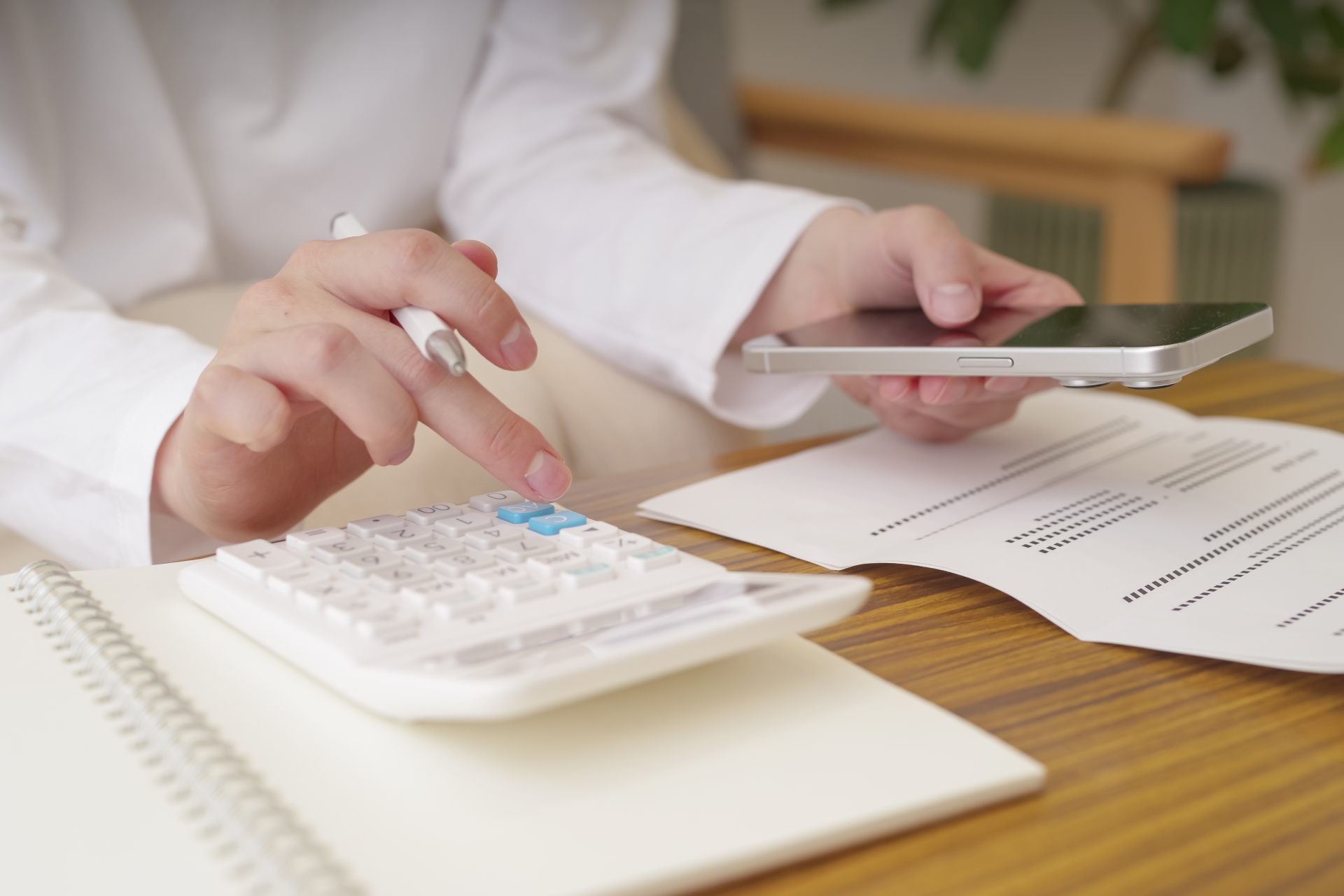 電卓でお金の計算をする女性