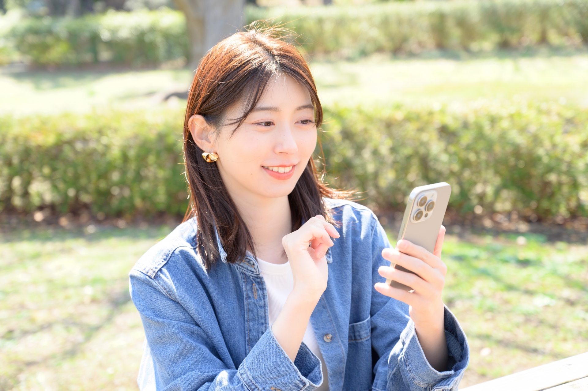 公園でスマホを操作する女性