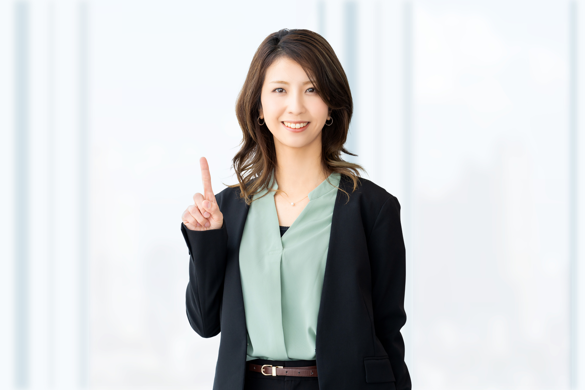 人差し指を立てて案内する笑顔の女性