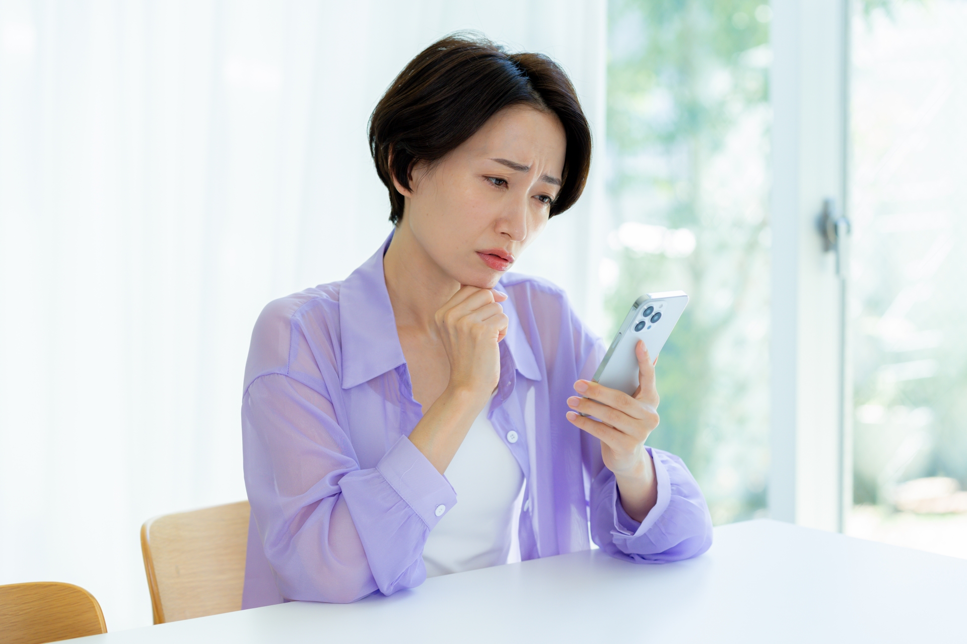 スマホを持って考える女性