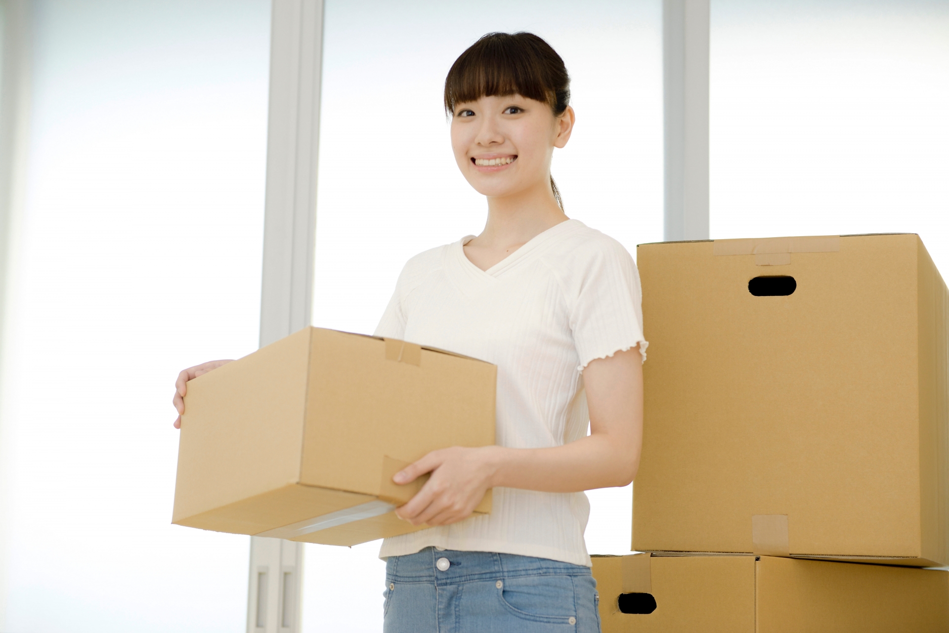引越し作業中に段ボール箱を持って立つ女性2
