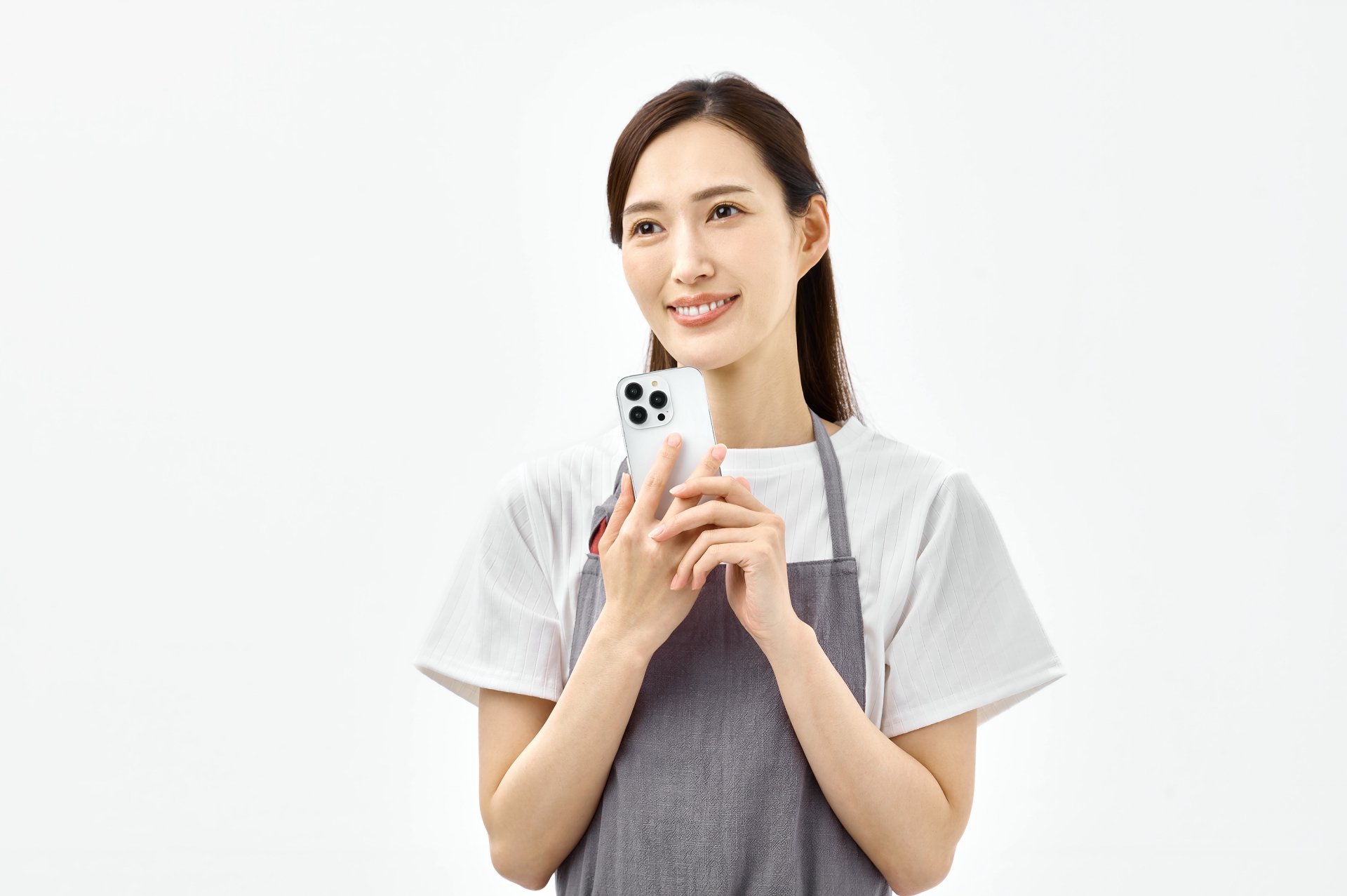 スマホを持つエプロンの女性