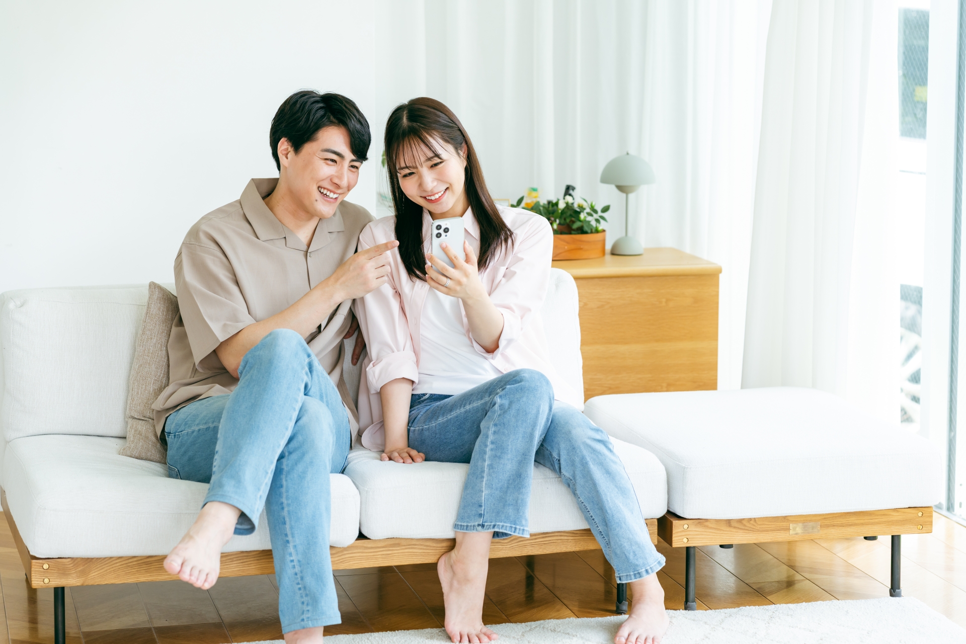リビングでスマホを見るカップル