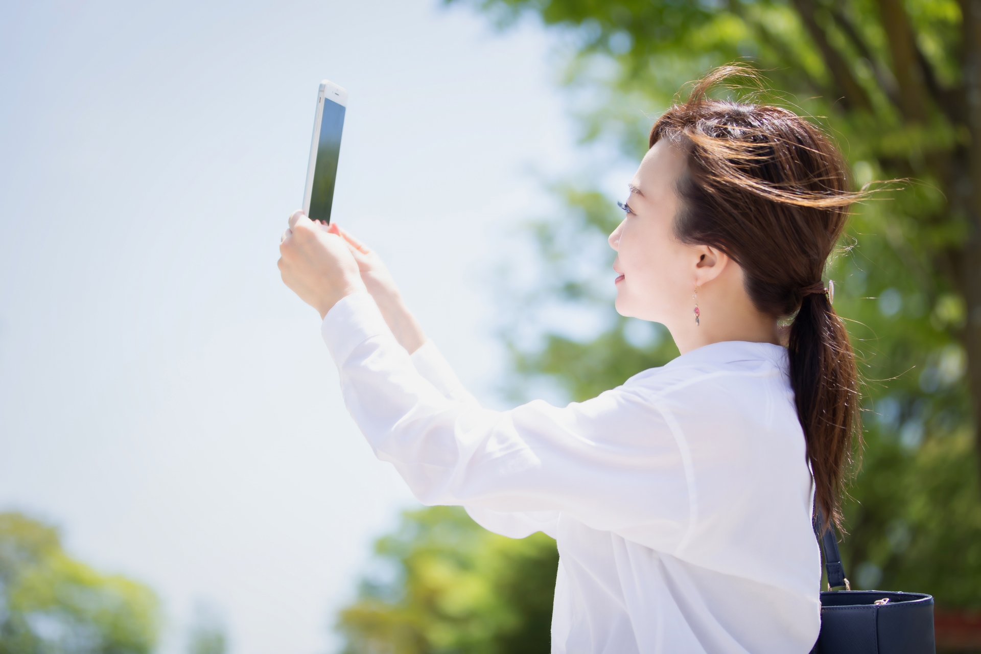 スマホを持って撮影する女性