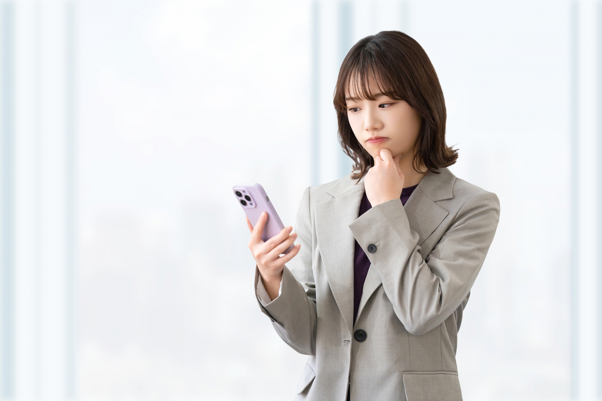 スマホを見て考える女性