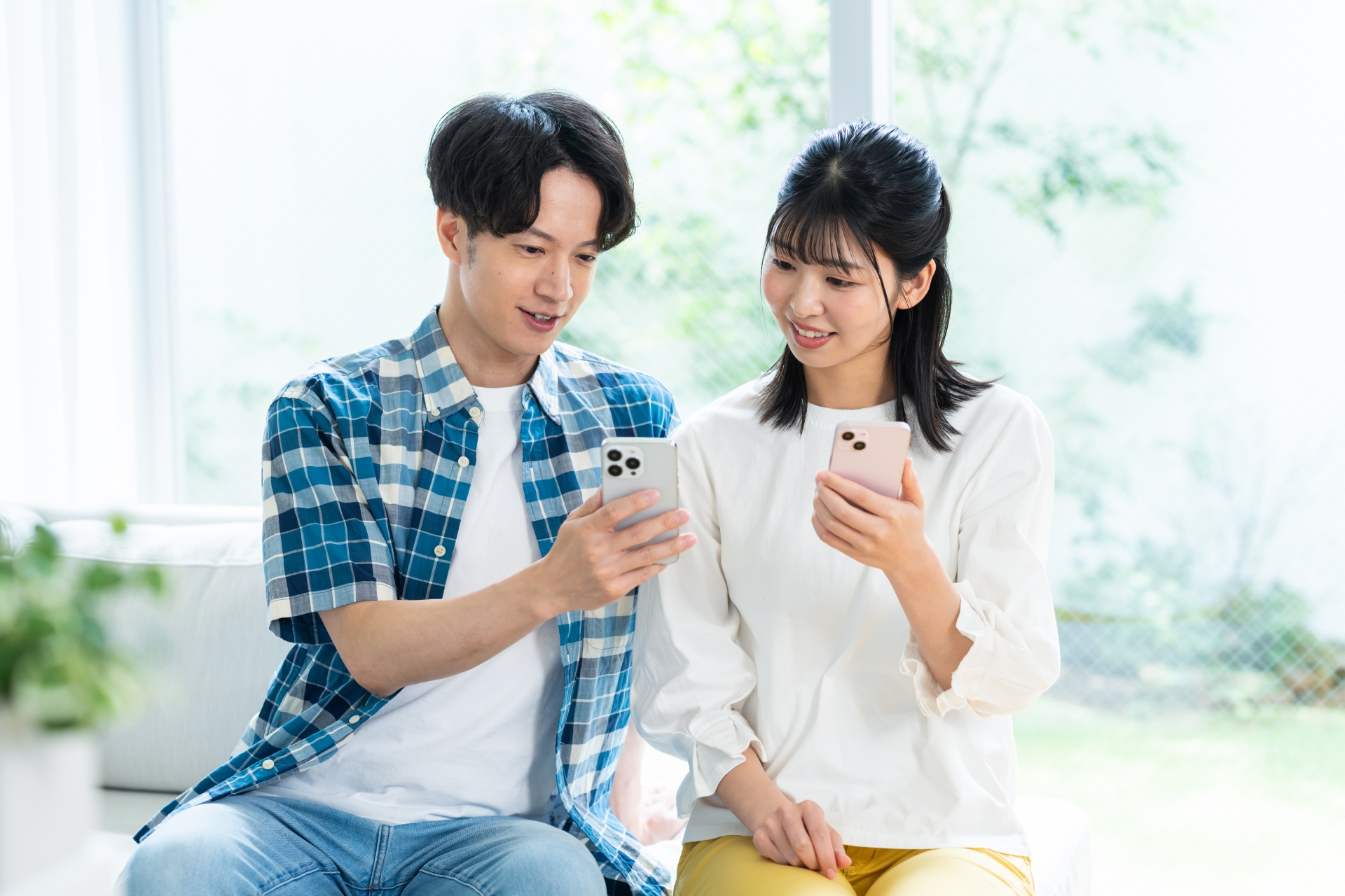 リビングでスマホを見るカップル