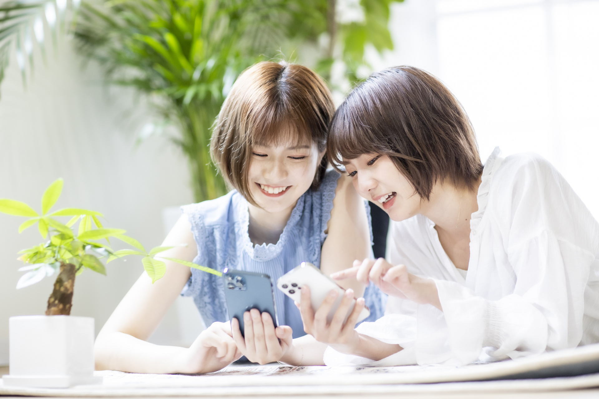 スマホを見せ合い楽しそうな女性