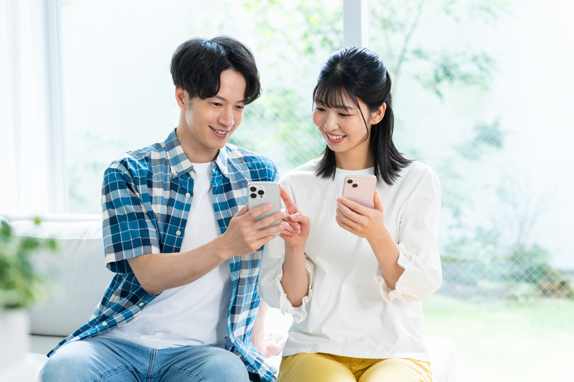 リビングでスマホを見るカップル