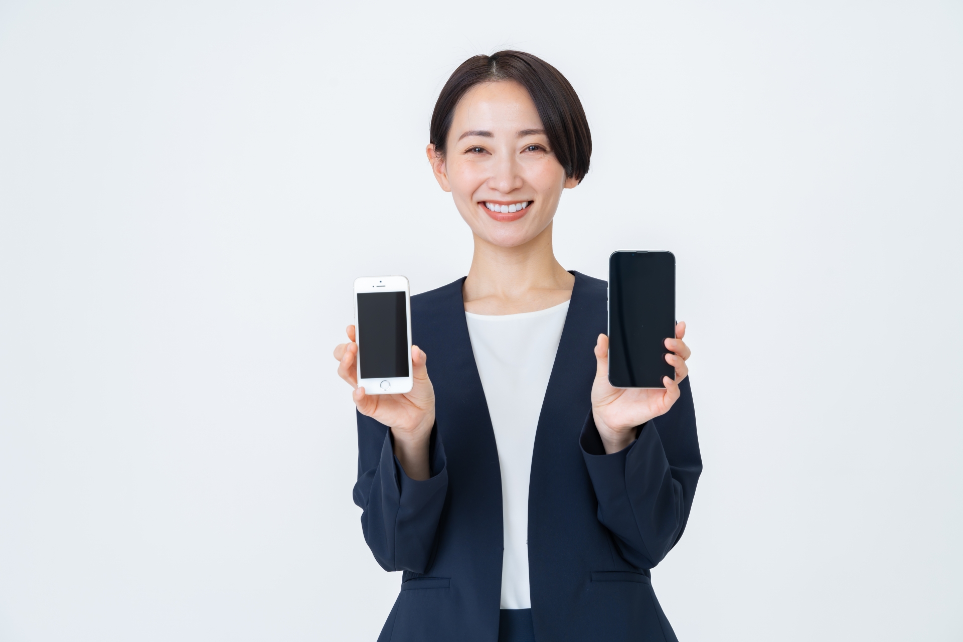 両手にスマホを持つ笑顔の女性