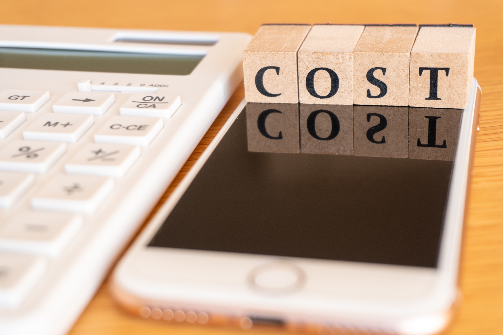 COSTの文字とスマホと電卓