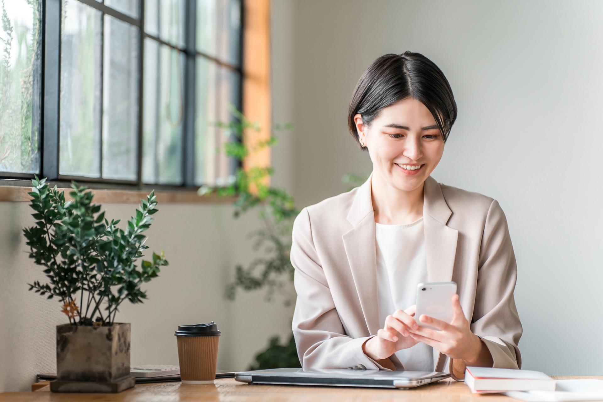 カフェでスマホを使う若いビジネスウーマン