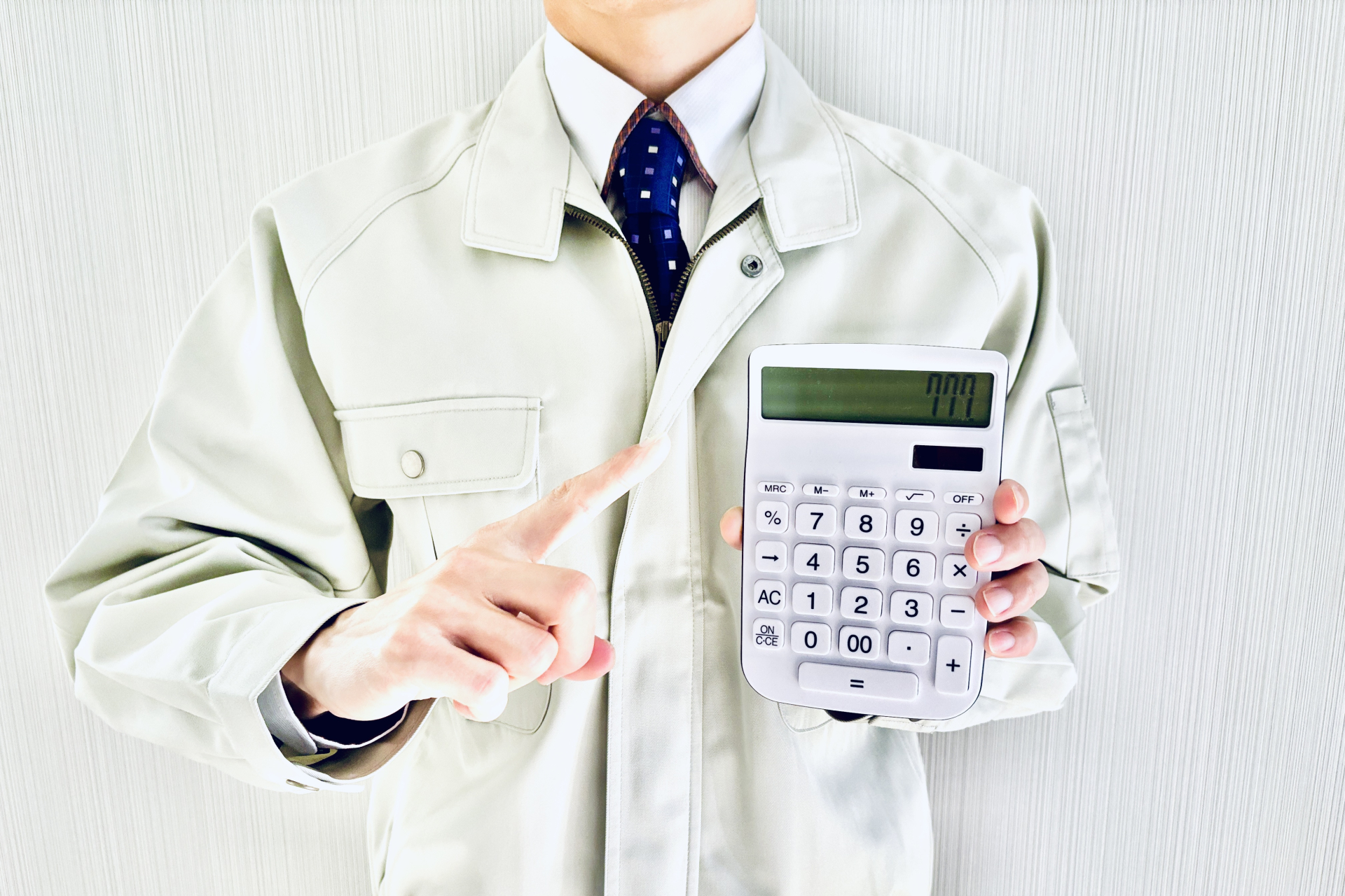 電卓を指差す作業着姿の男性ビジネスマン