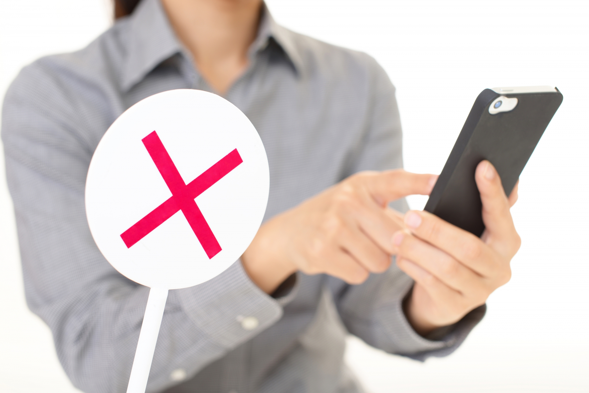 バツのサインとスマホを見る人