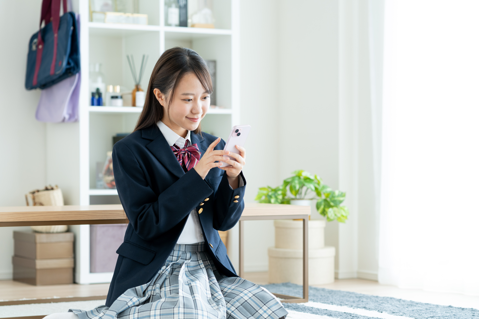 部屋でスマホ使う女子高生