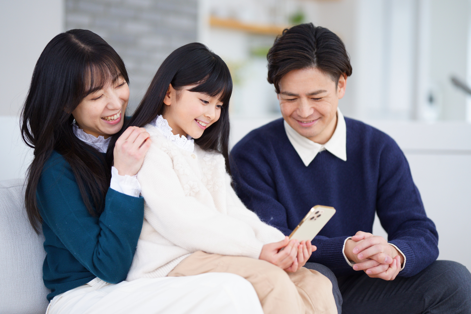 座って携帯を見る家族