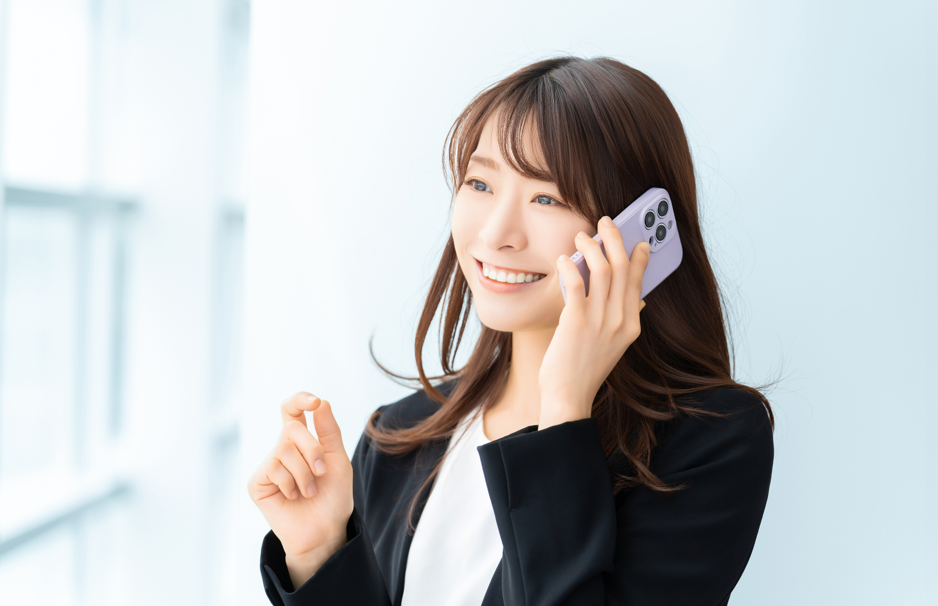 スマホで話す笑顔の女性・ビジネスウーマン