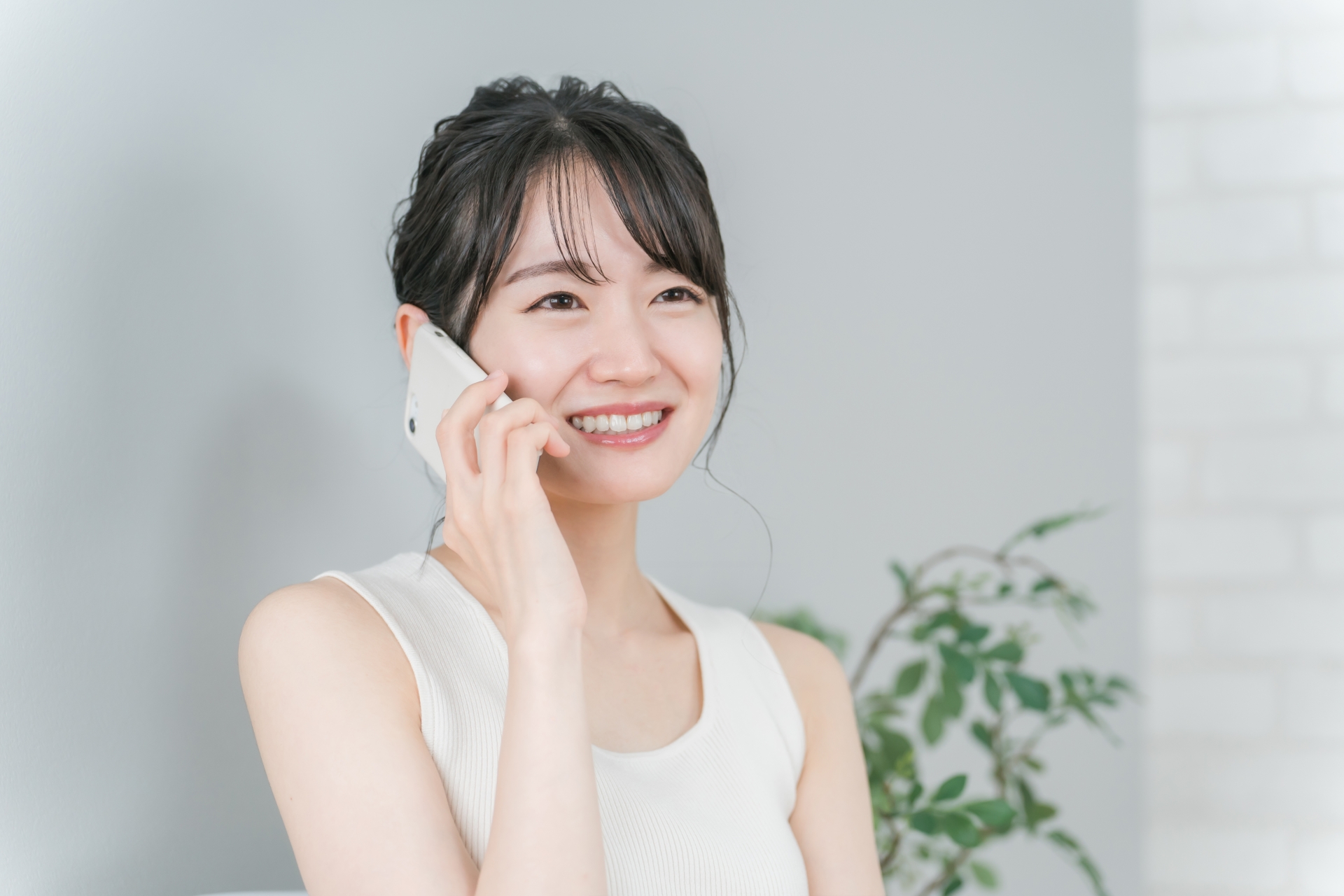 笑顔でスマホを使って電話する女性