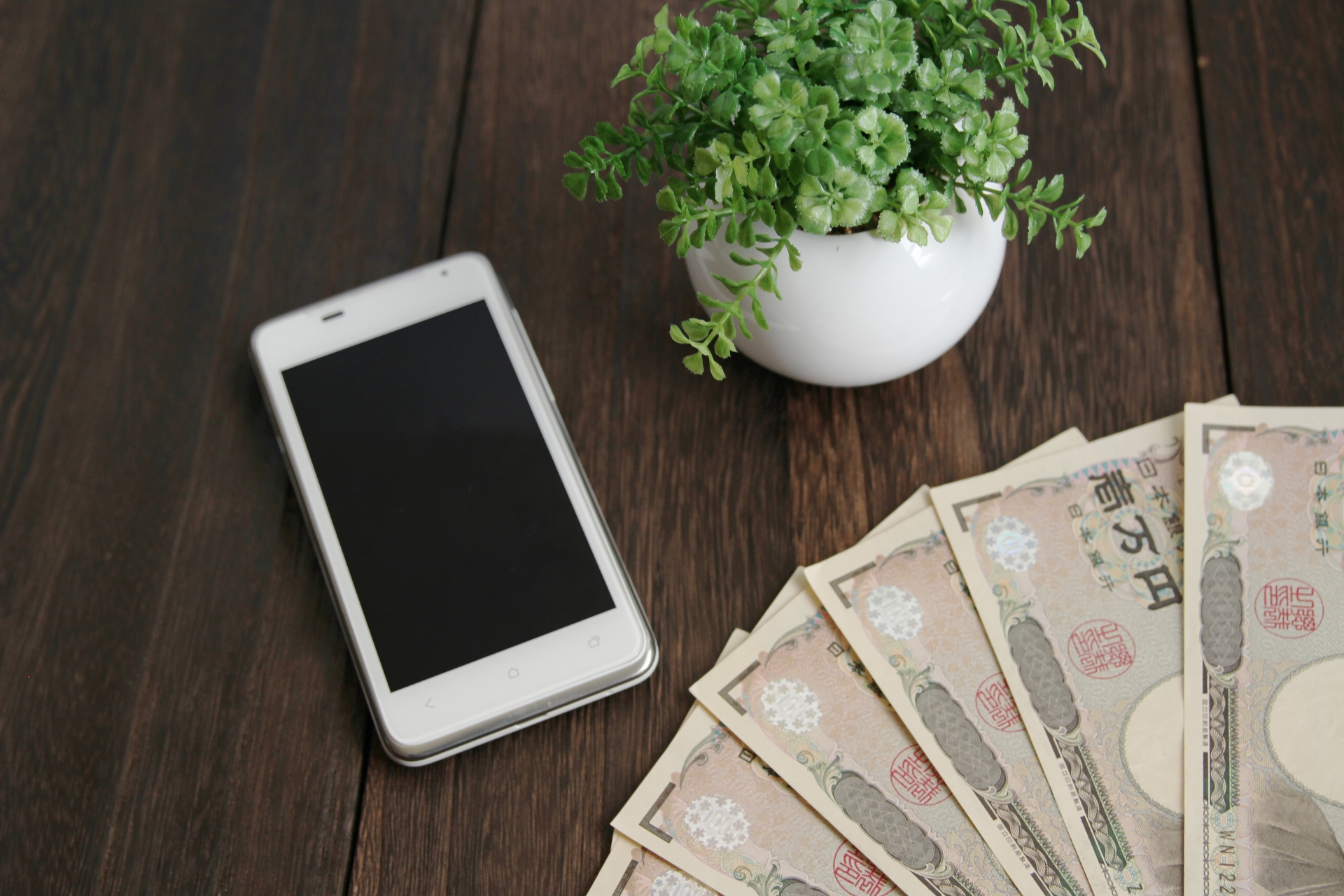 現金とスマホの画像