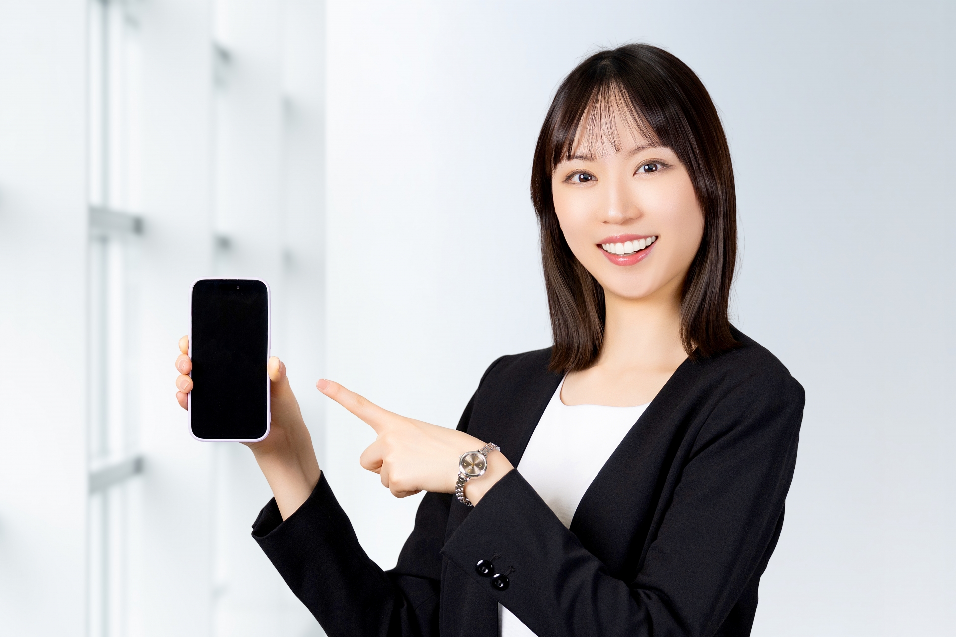 スマホを指差す笑顔の女性