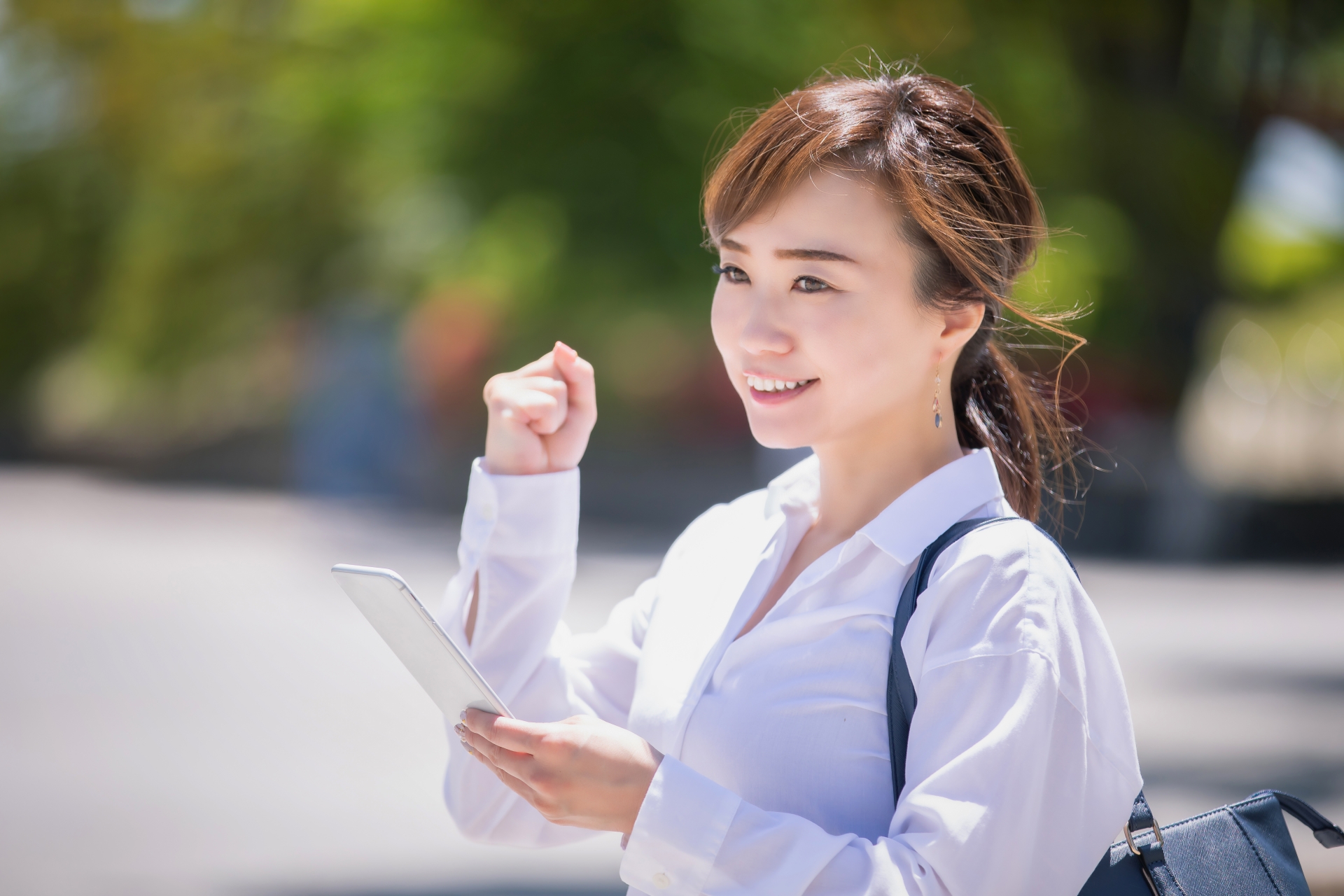 スマホを持ってガッツポーズする女性