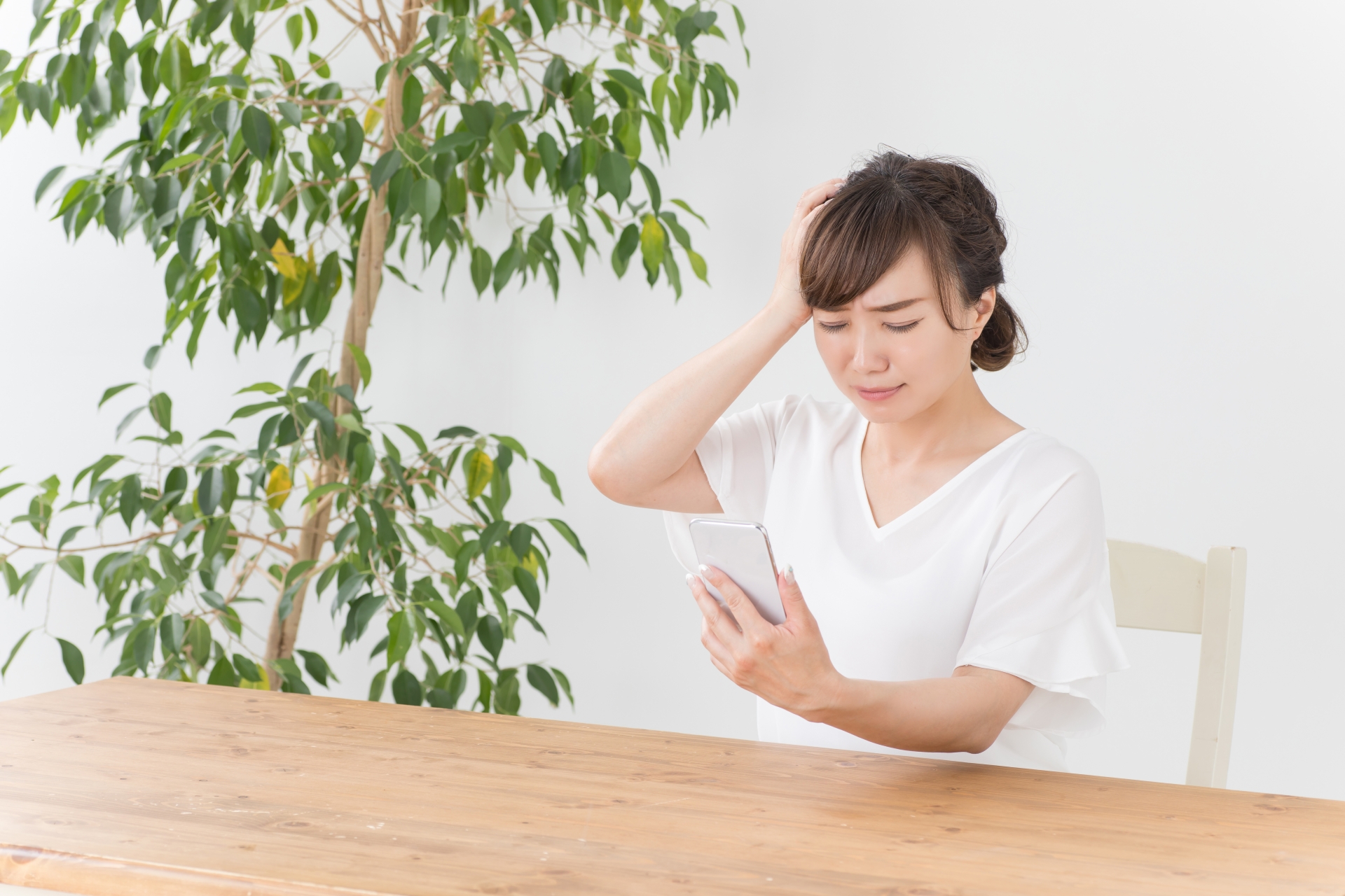 スマホを見て困る女性