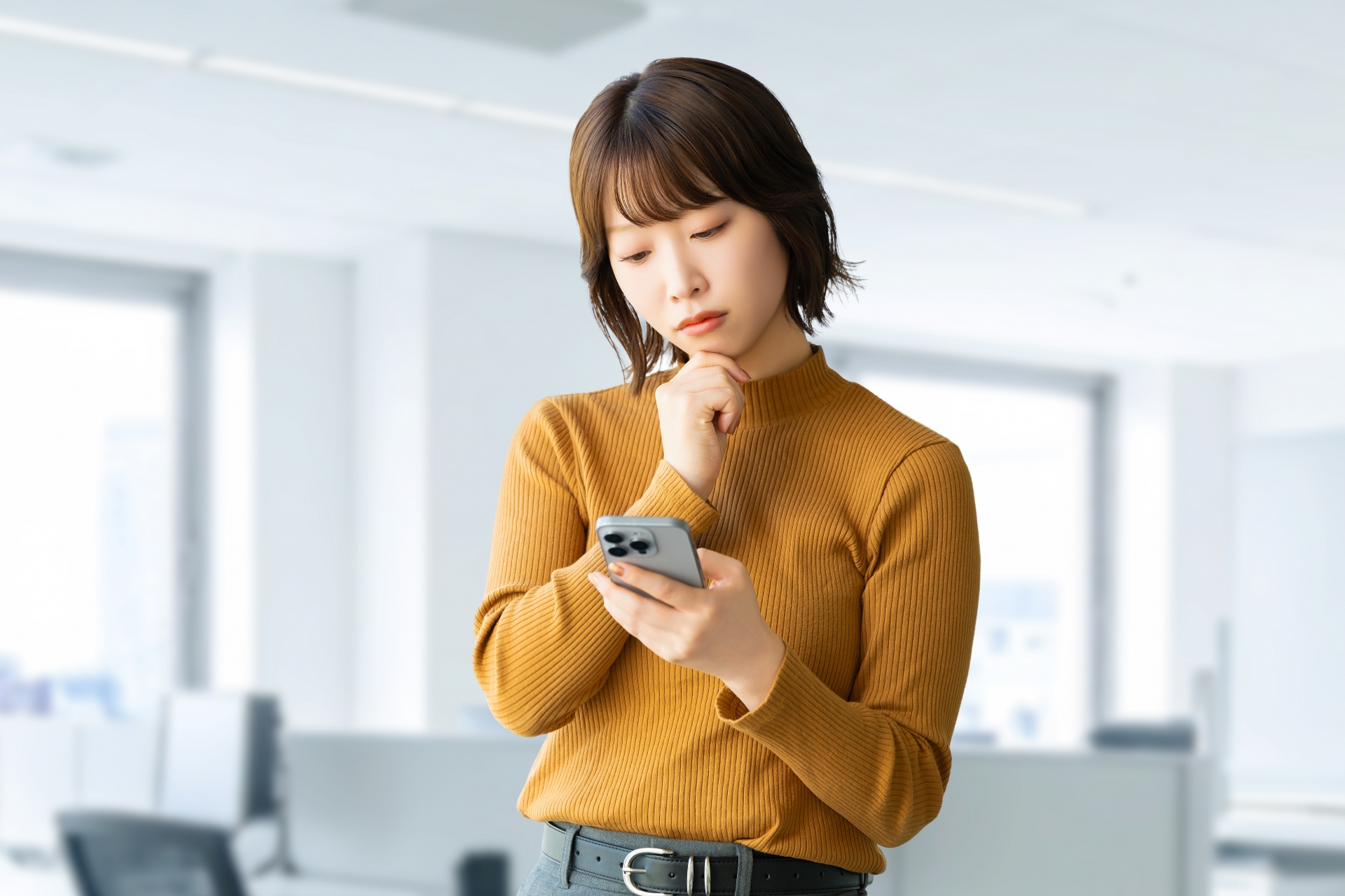 スマホを見て考える女性・ビジネスウーマン