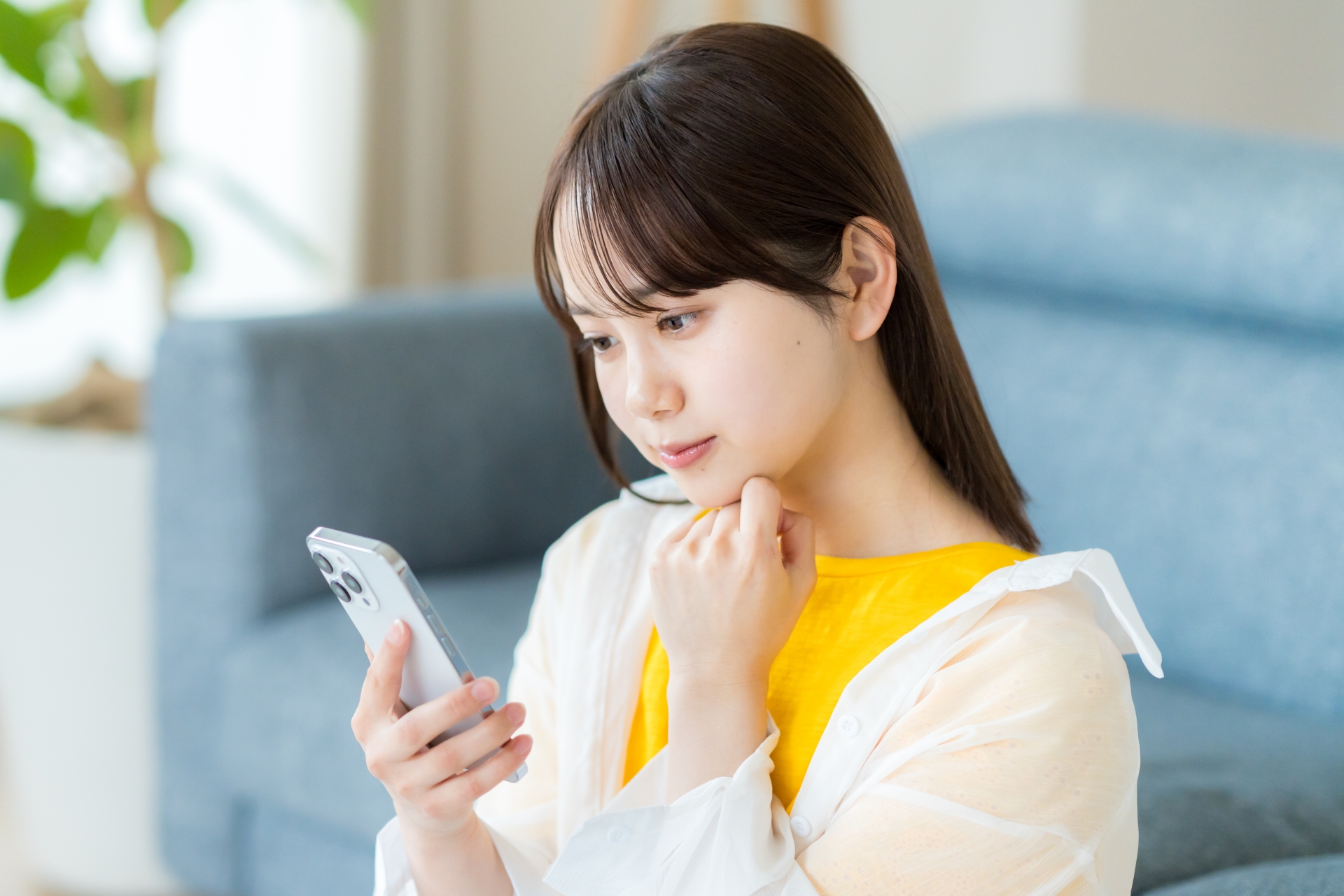 スマホを見て考える若い女性