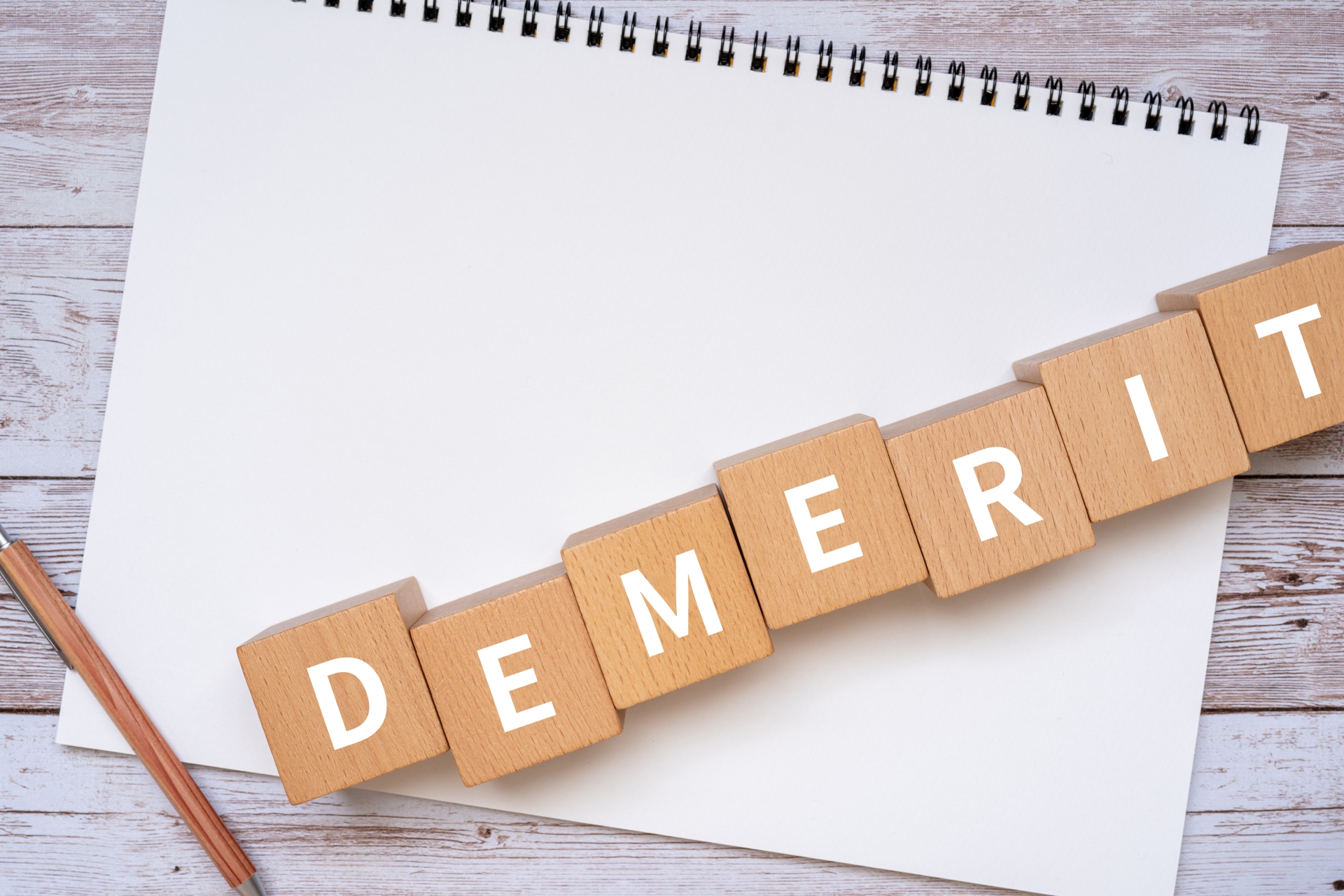 「DEMERIT」と書かれた積み木