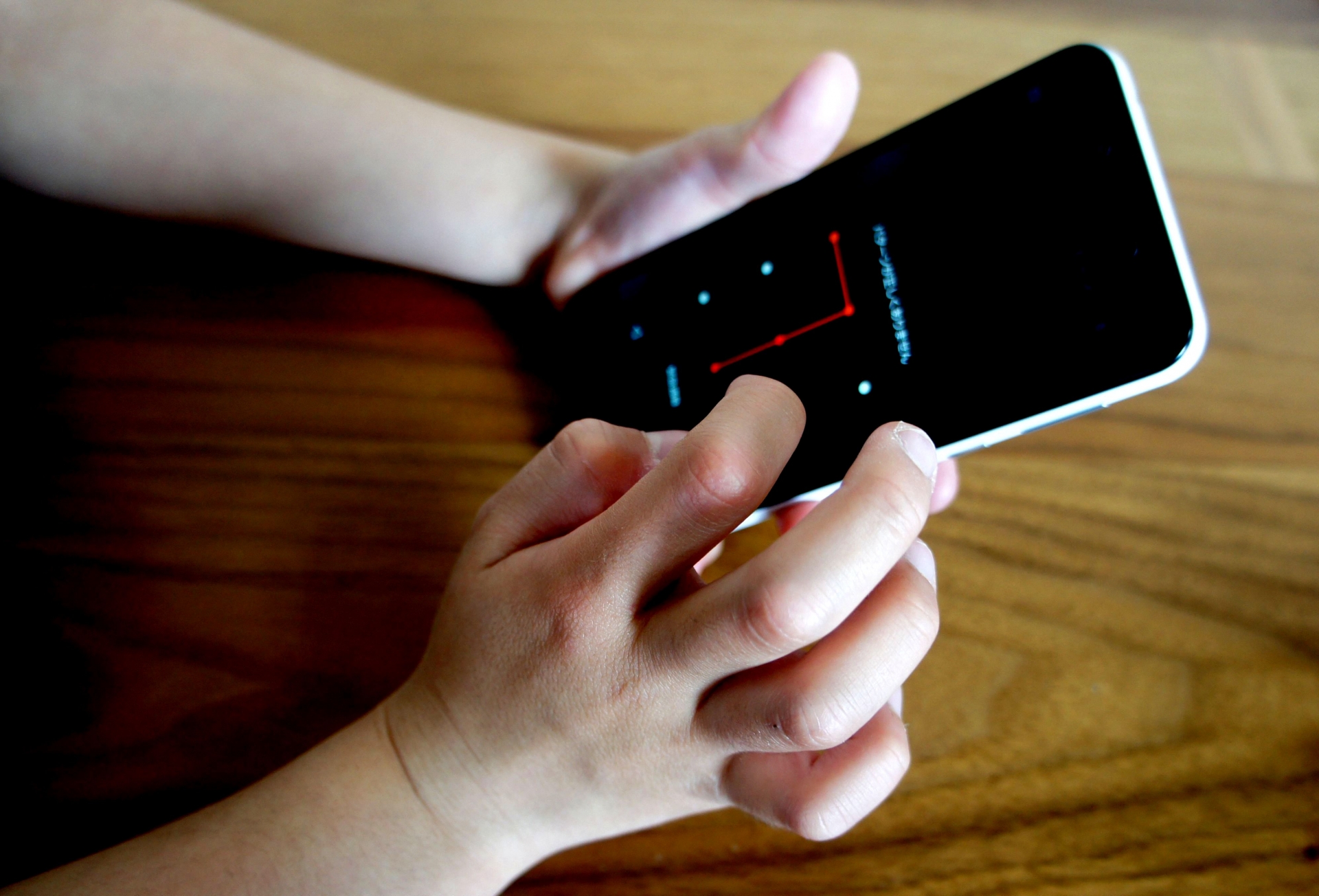 机の上でスマホを操作する