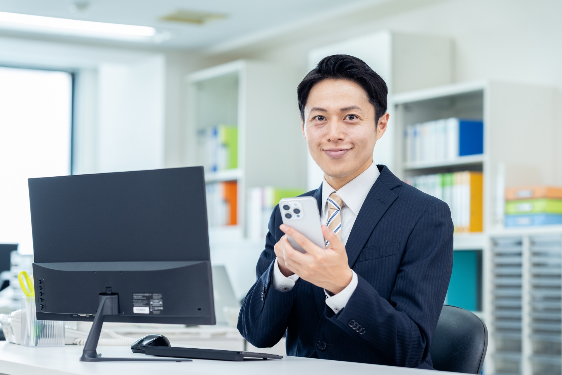 オフィスでスマホを使うビジネスマン
