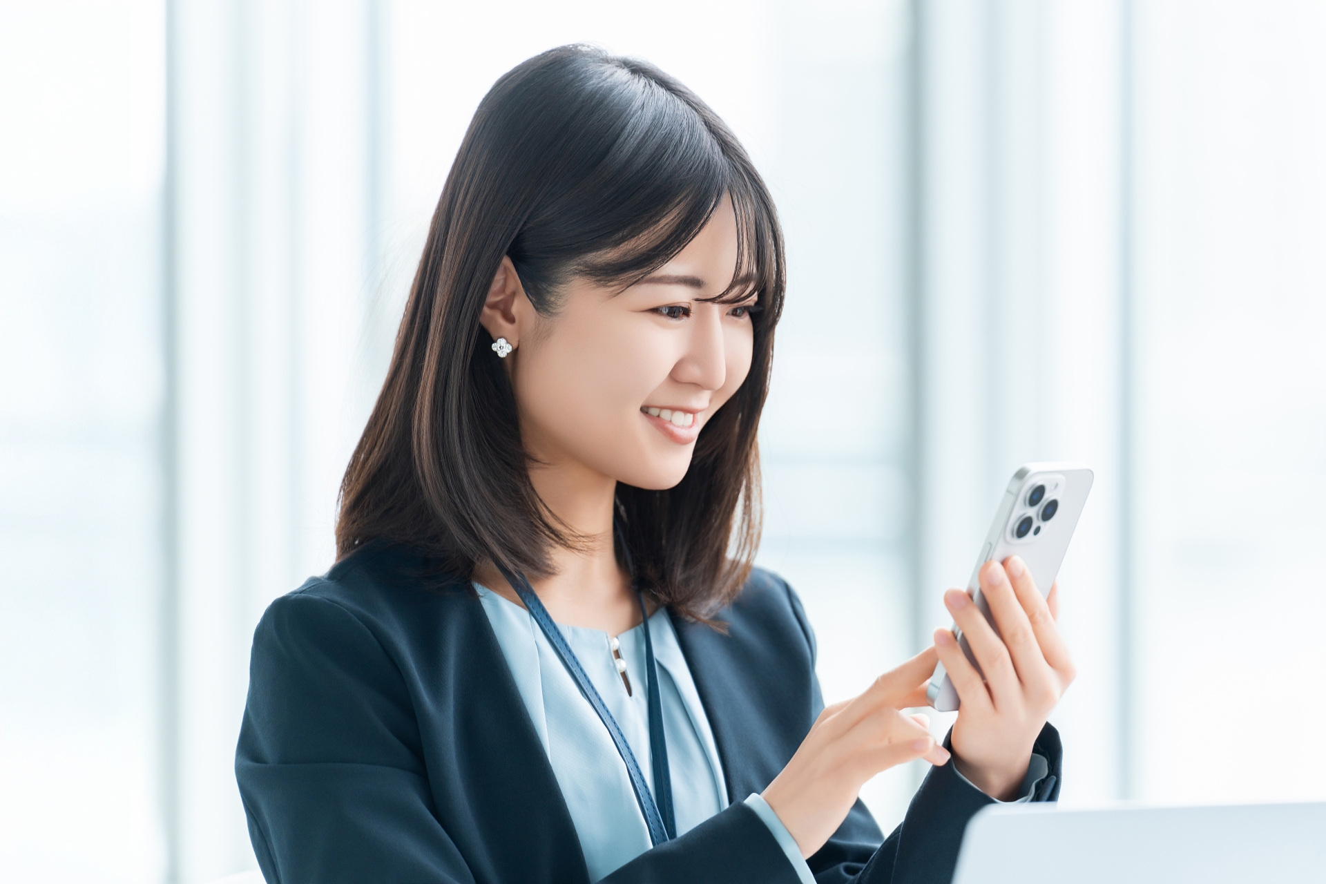 スマホを使う笑顔の女性・ビジネスウーマン