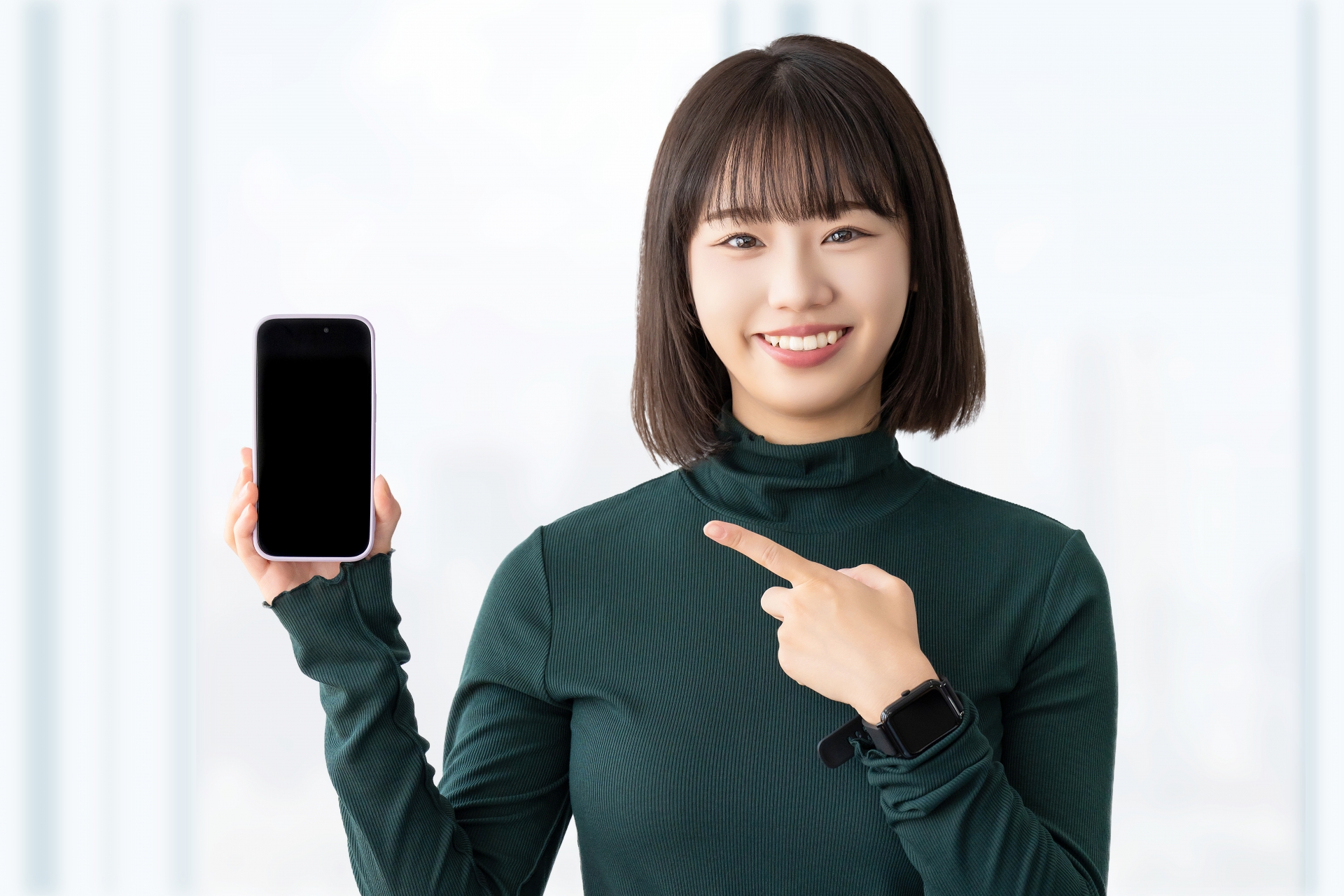 スマホを指差す笑顔の女性